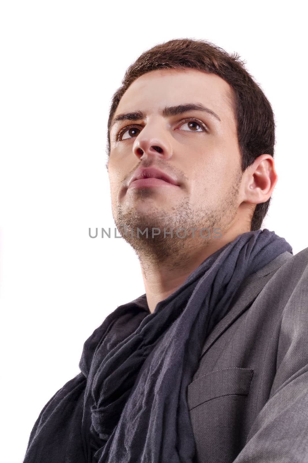 View of a young man standing against a white  background. 