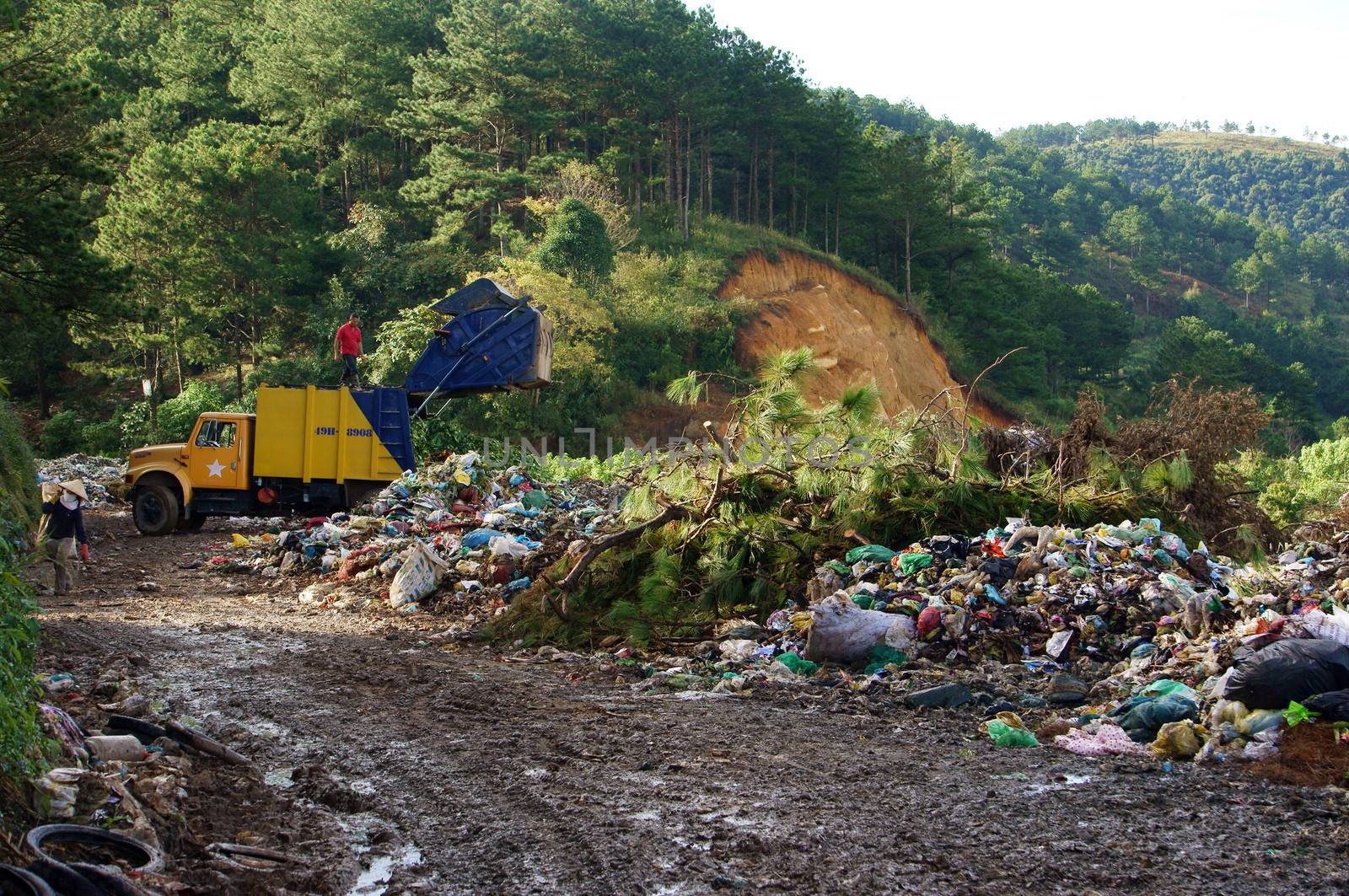 Garbage truck empty out the rubbish at dumping ground. Dalat, Viet Nam- September 05, 2013