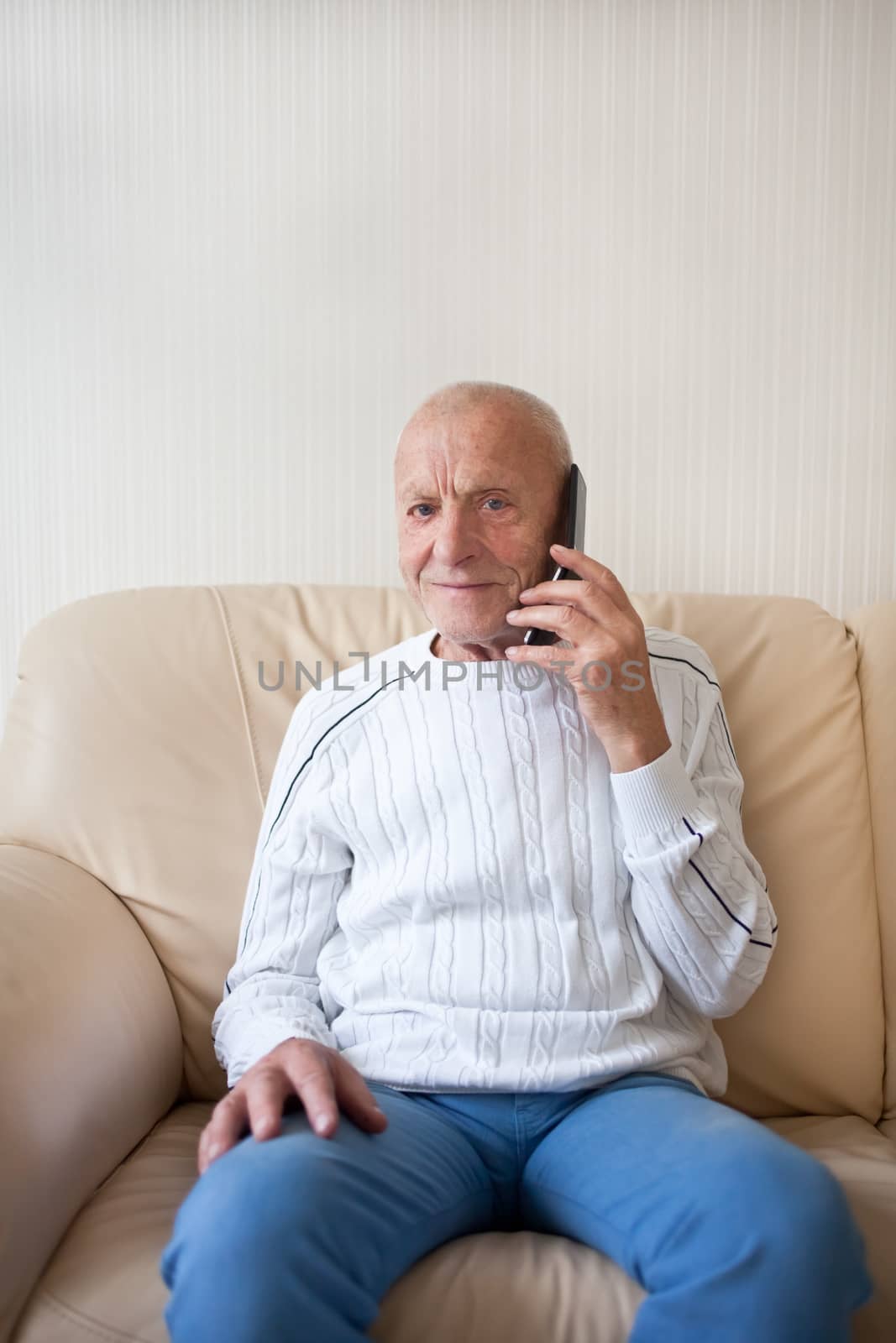 Smiling old man is talking on the phone
