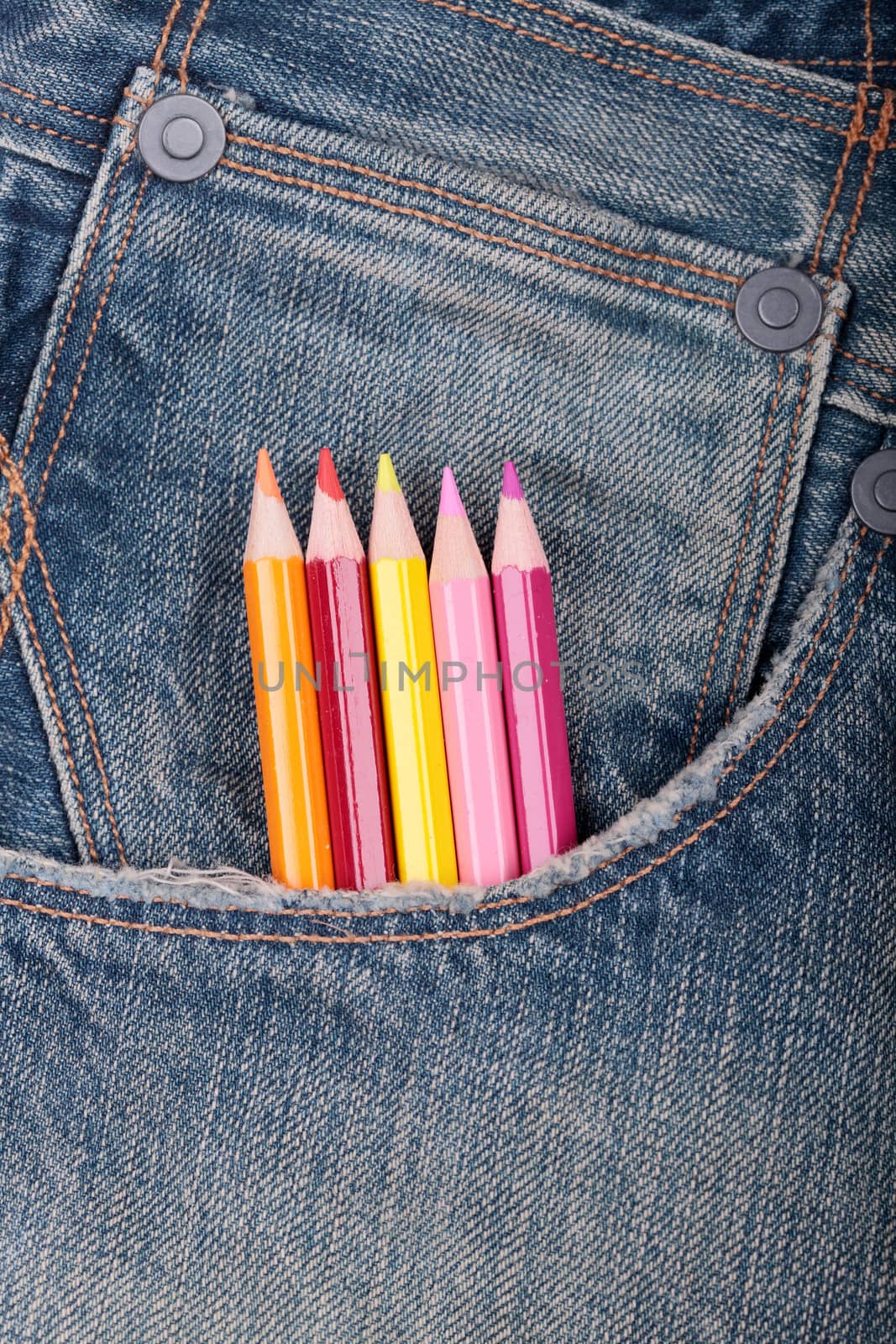 some pencil of different colors on a jeans pocket