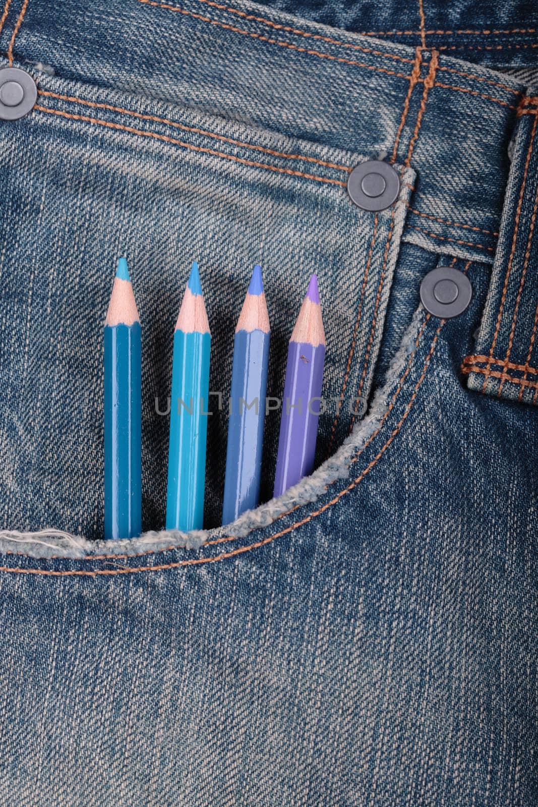 four blue pencils on a jeans pocket