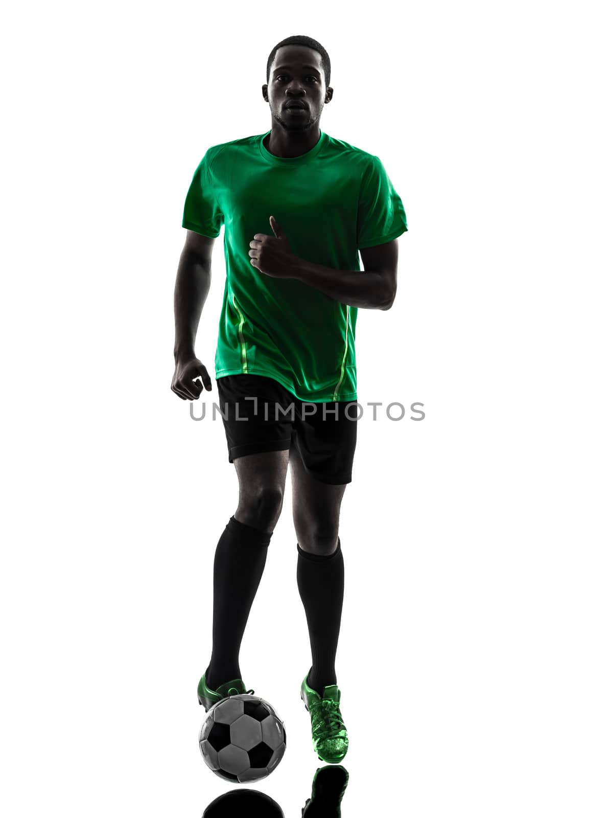 one african man soccer player green jersey running with football  in silhouette  on white background