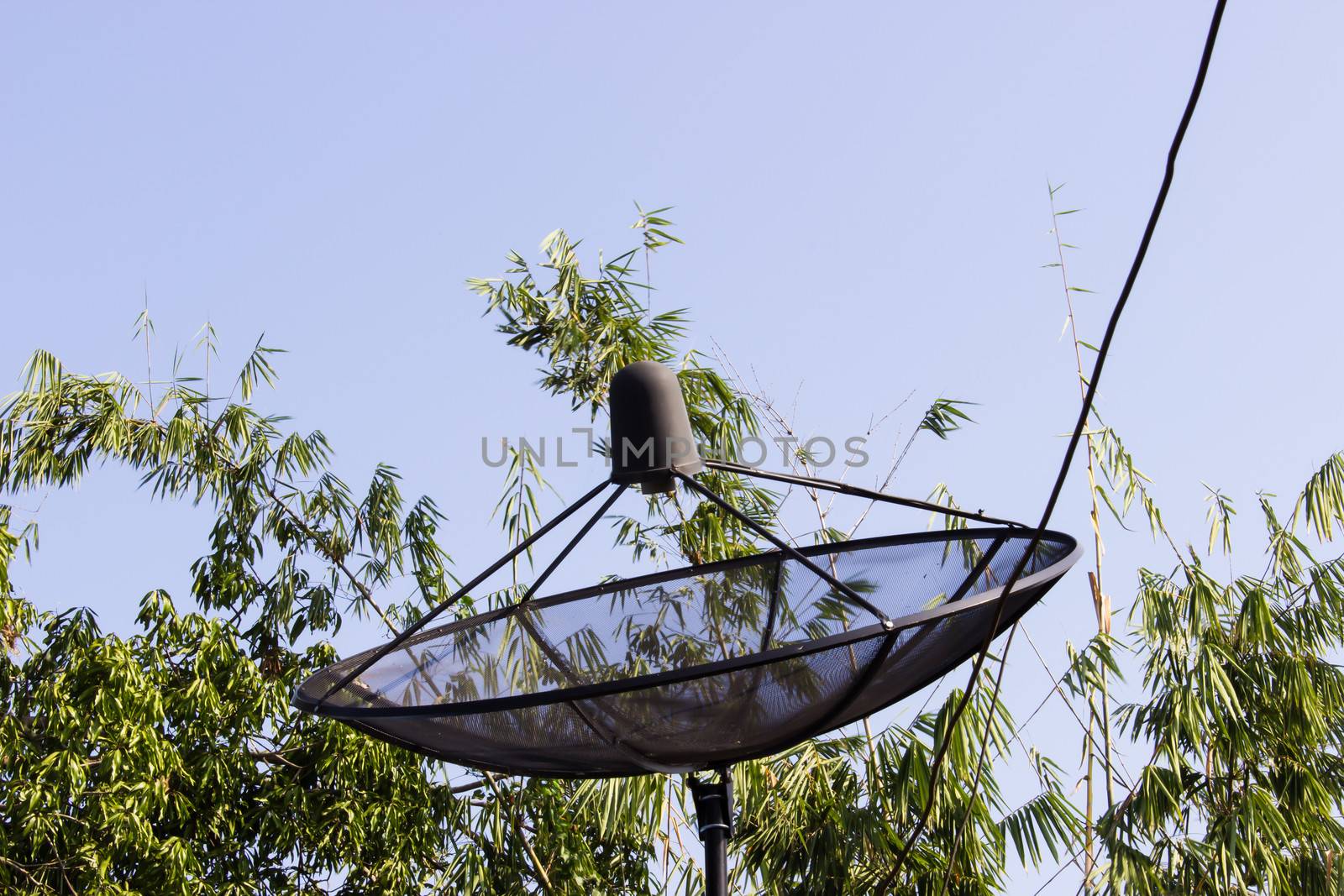 Satellite dish and cloudy blue sky background  and tree behind