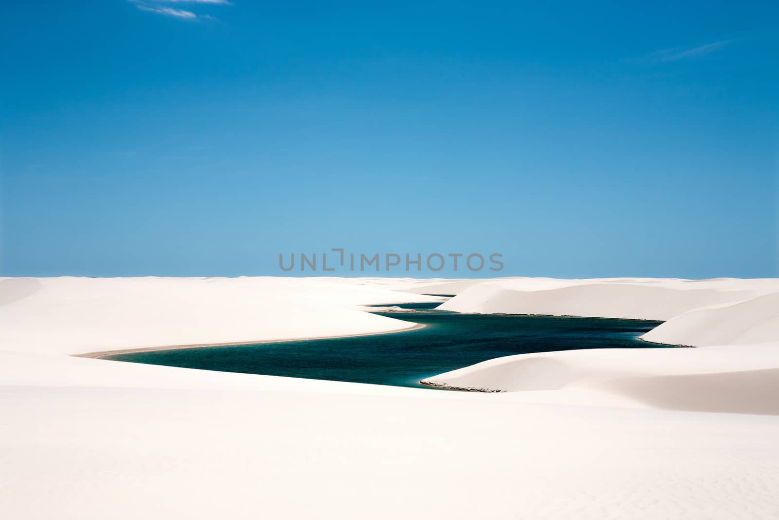 view of lagoa azul in desert white sand dunes of the Lencois Maranheses National Park in brazil