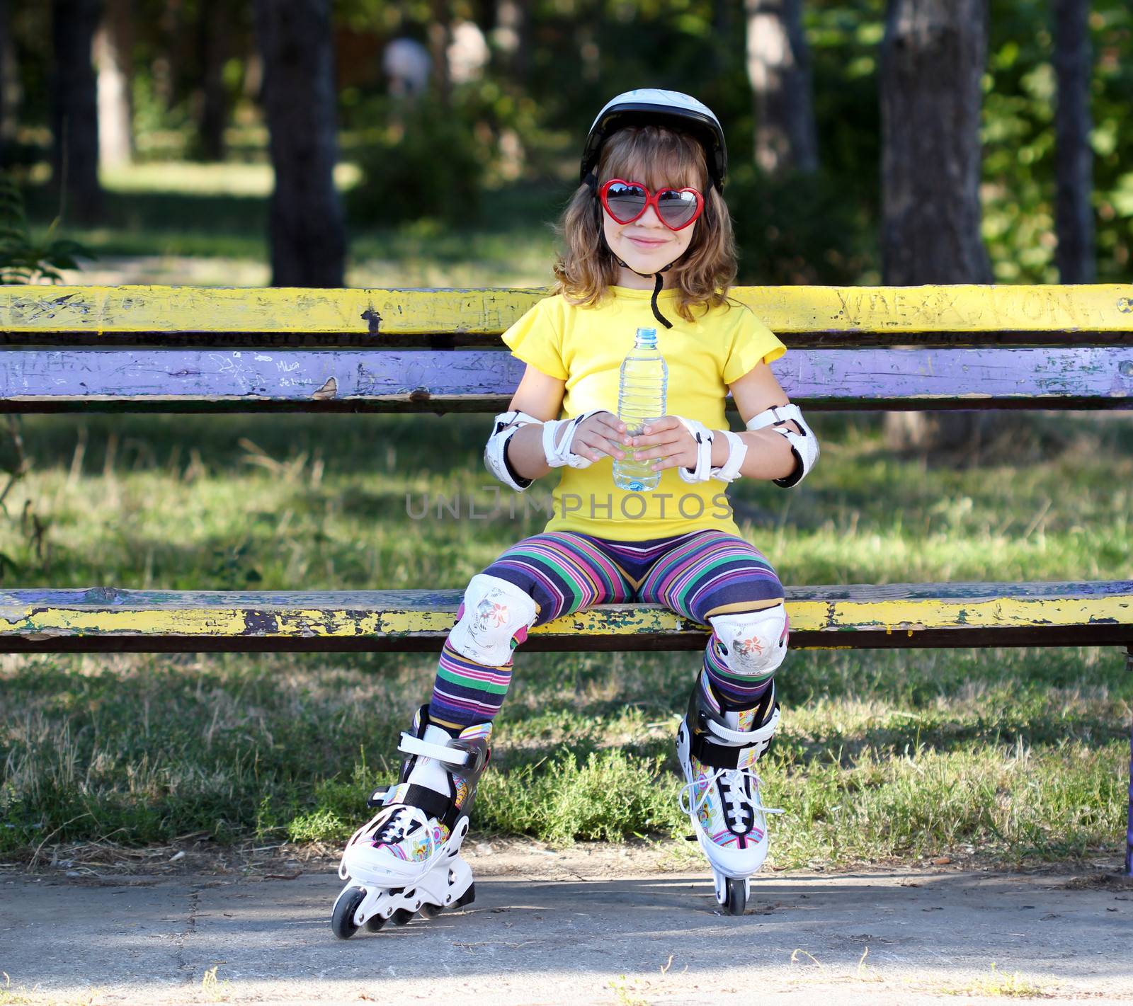 little girl with roller skates and water