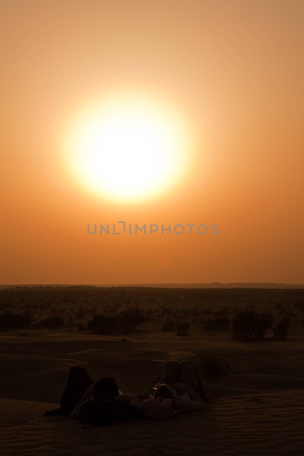 romantic couple looking at the sunset at khuri dunes in thar desert near jaisalmer in rajasthan state in india