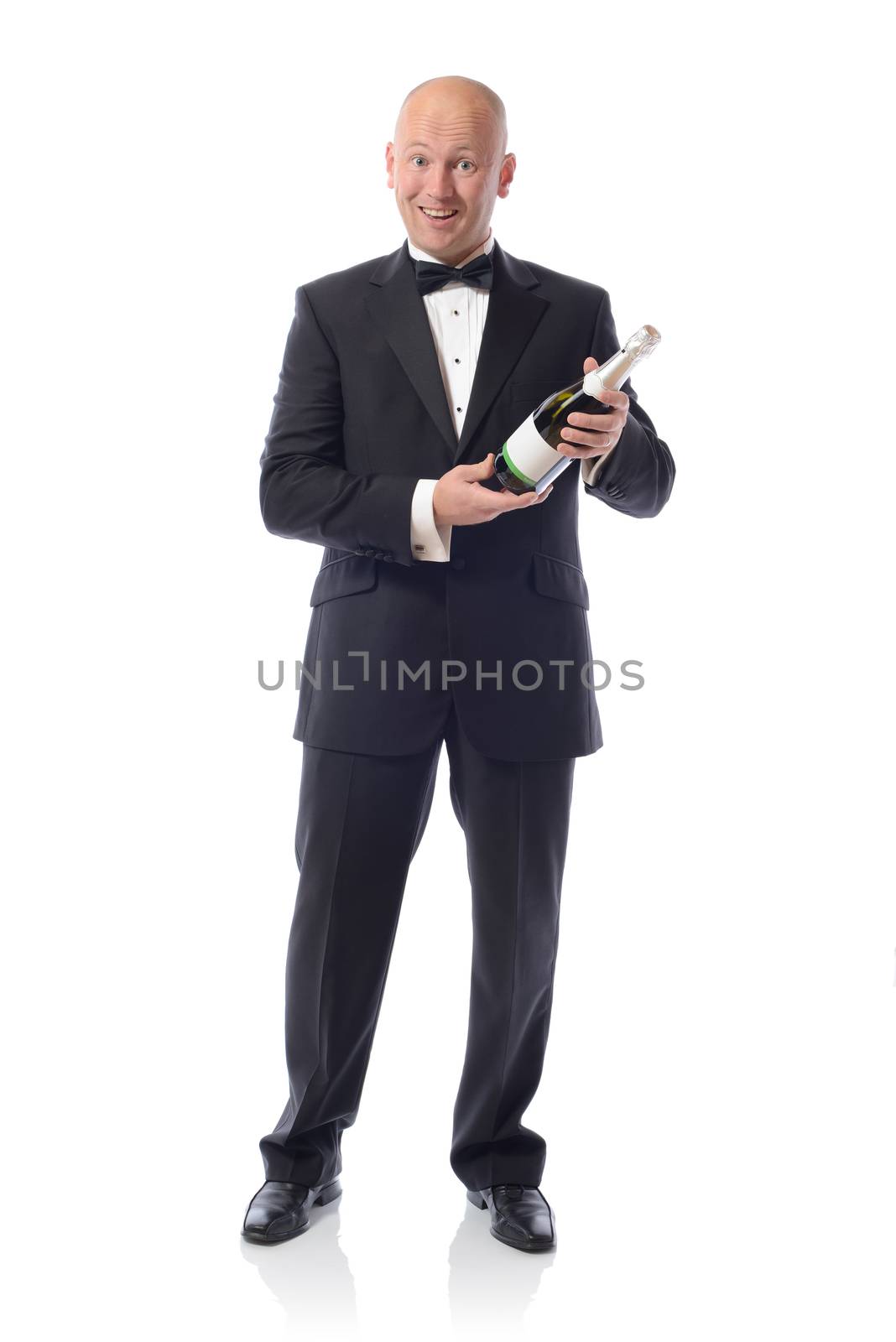 Middle aged Man in Tuxedo Holding a Champagne Bottle over a white background 