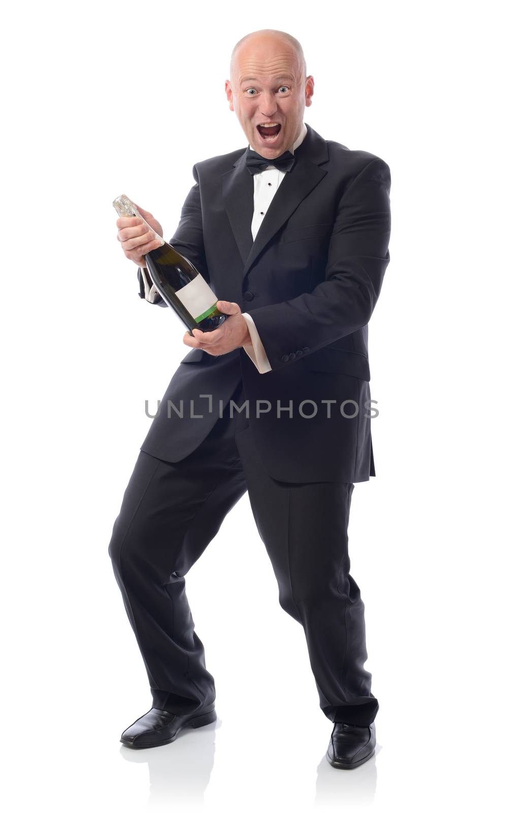 Man in tuxedo with a bottle of champagne winning