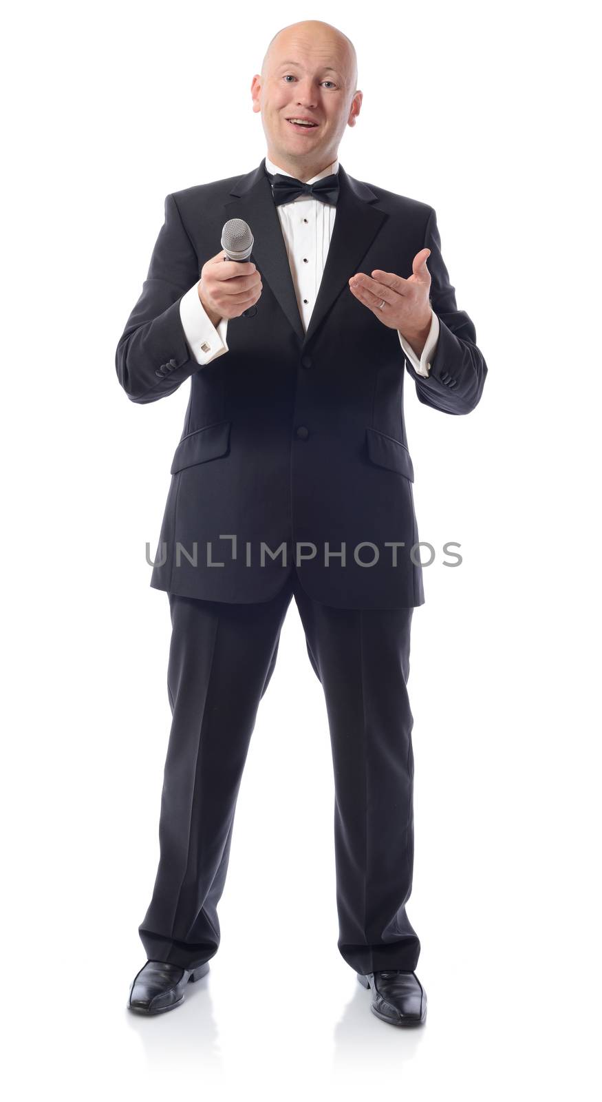 Man in a tuxedo offering microphone isolated on white 