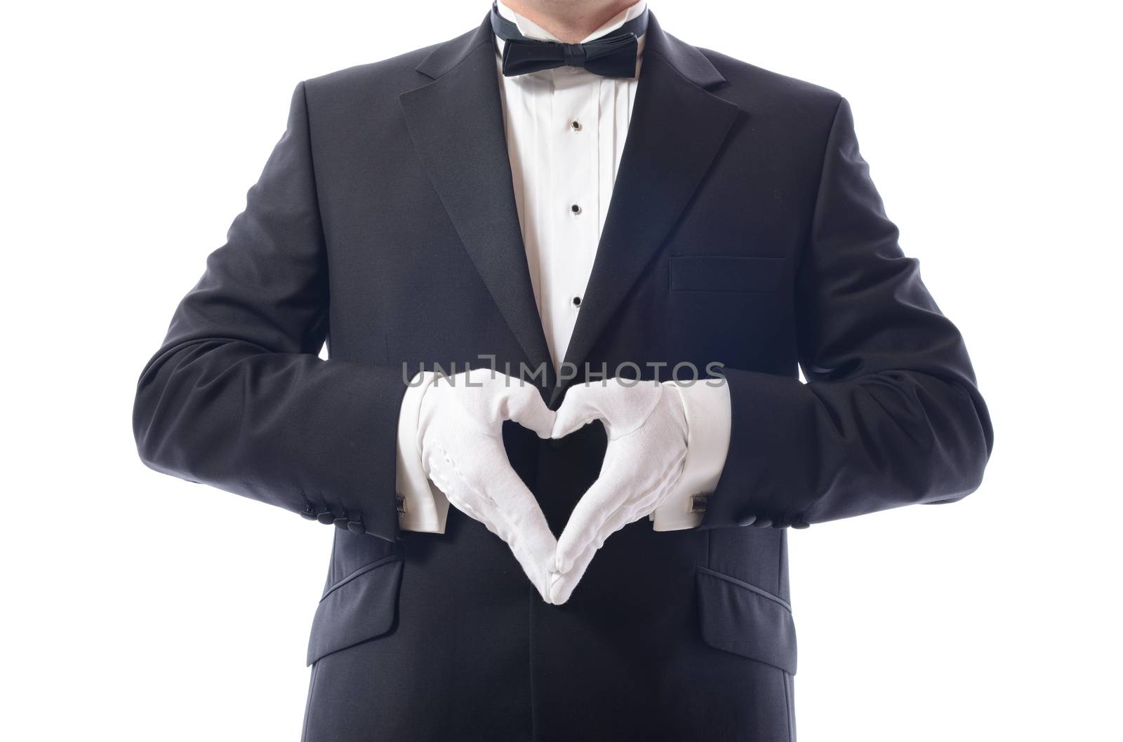 man in tuxedo with hamds in heart shaped pose