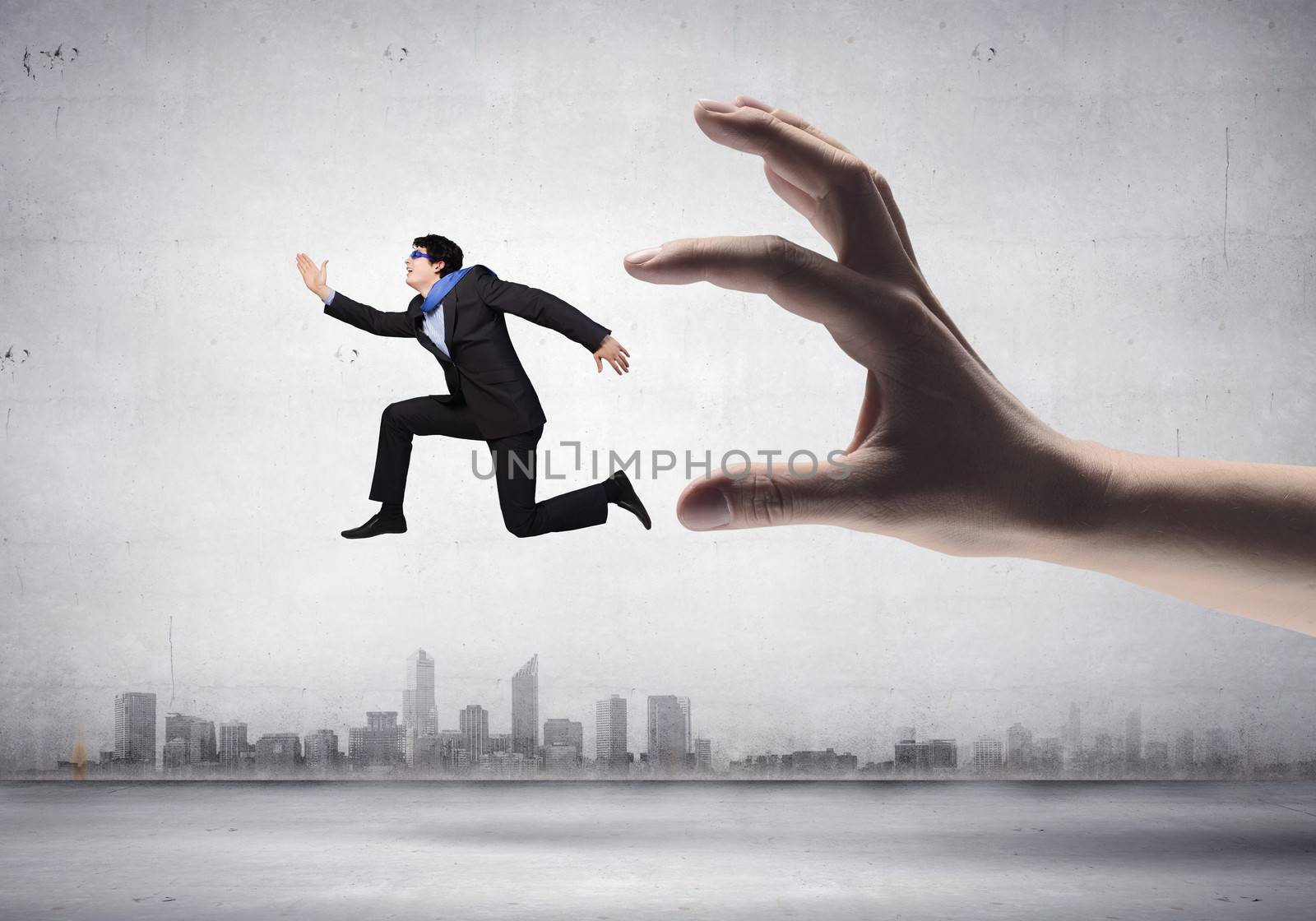 funny image of businessman trying to run away from hand