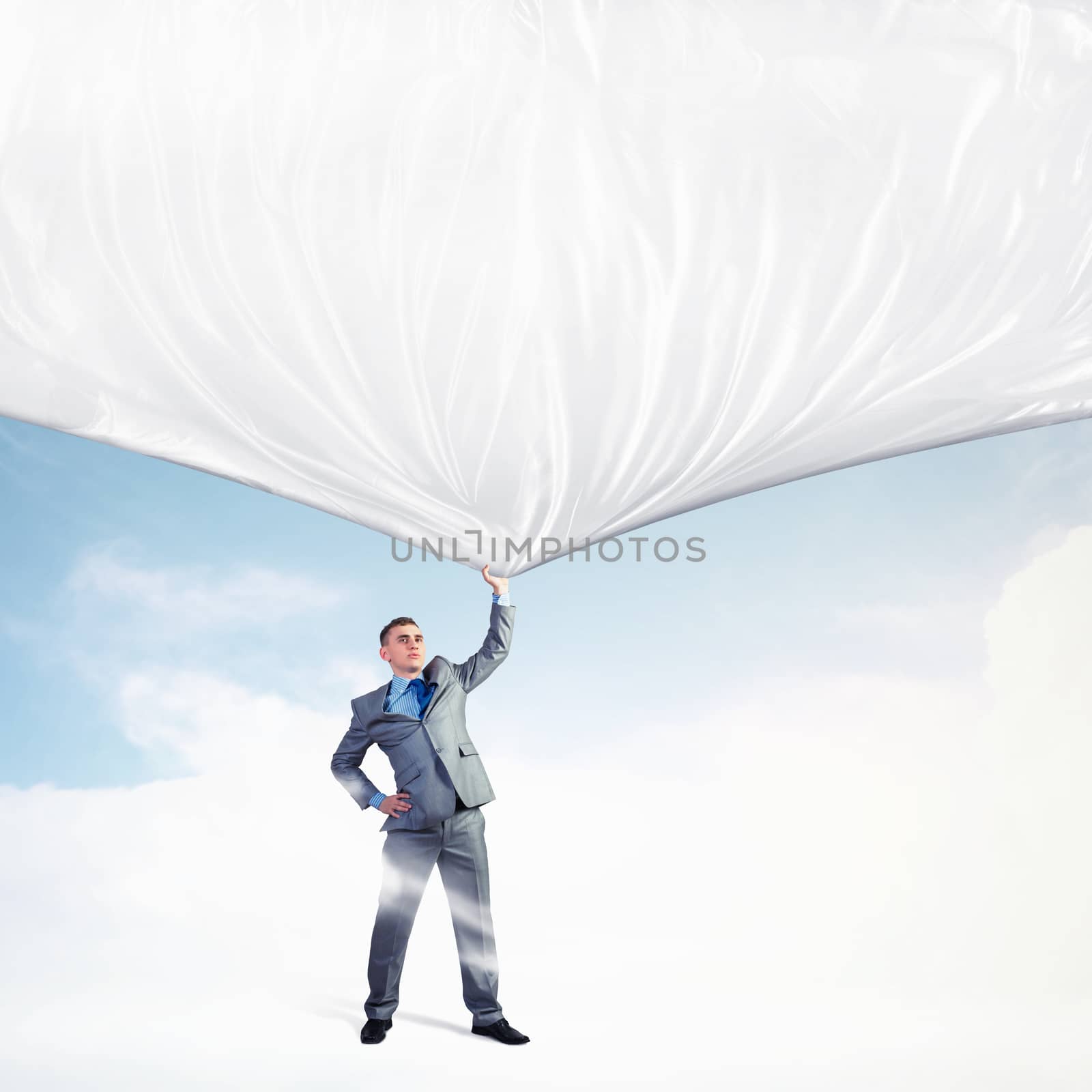 Image of young businessman pulling blank banner from above