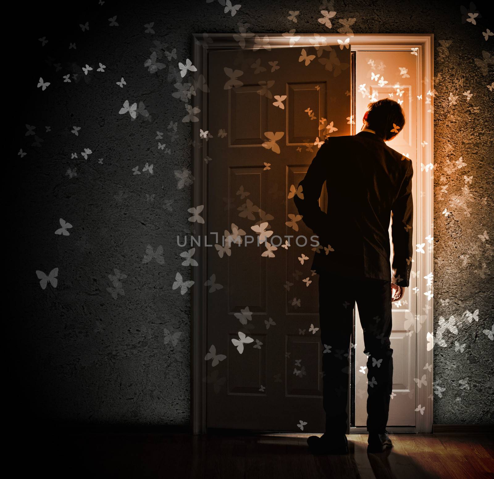 Image of young businessman standing with back opening door