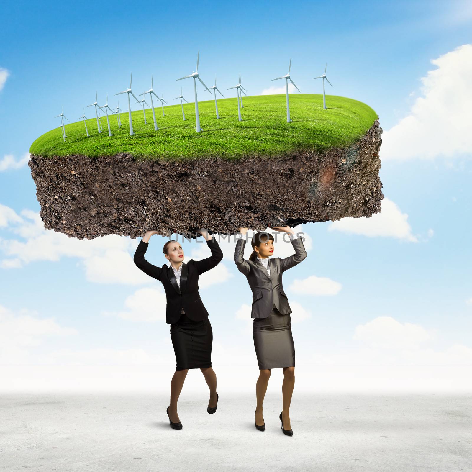 Image of two businesswomen holding lawn above head. Partnership and ecology