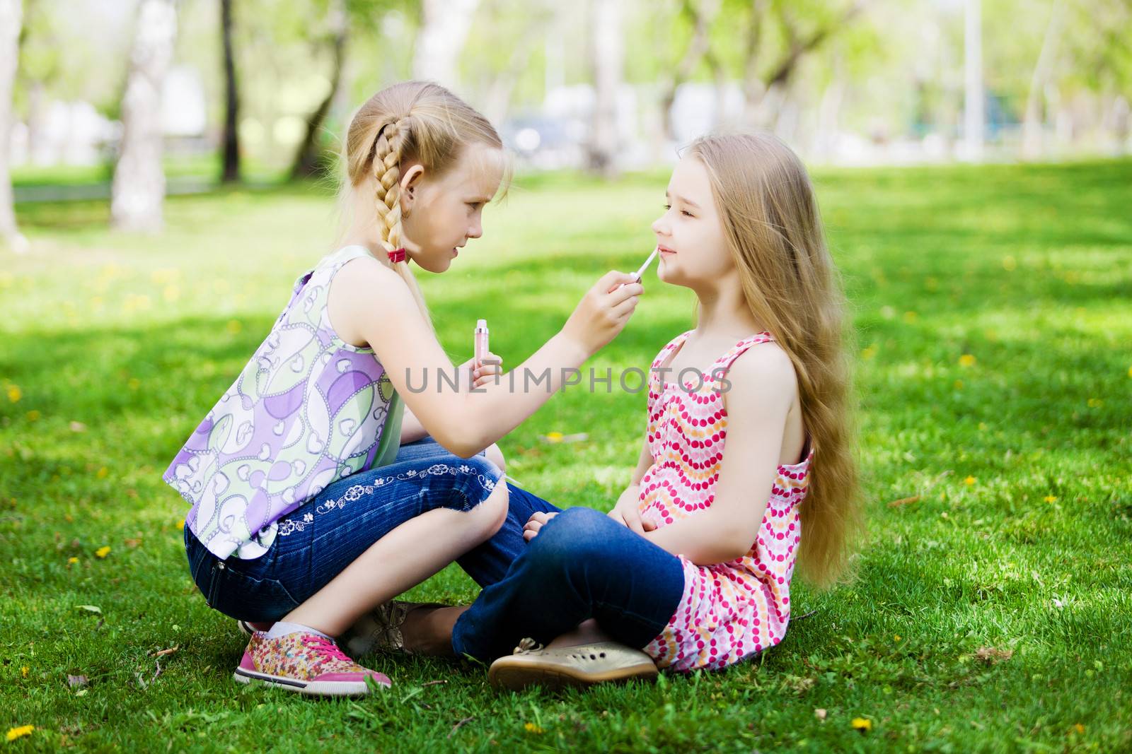 Image of two little cute girl playing on grass in park