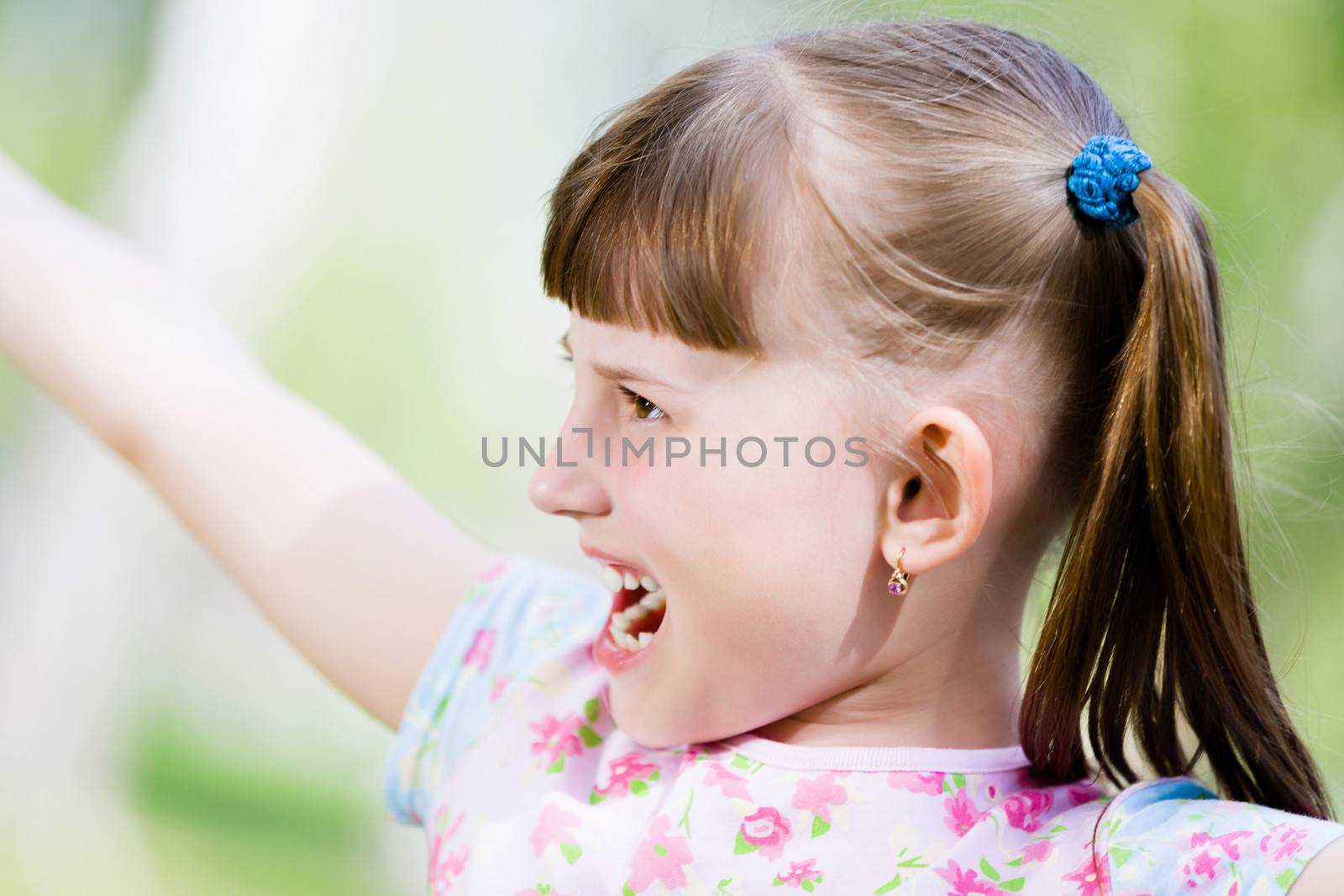 Image of little cute girl playing on grass in park