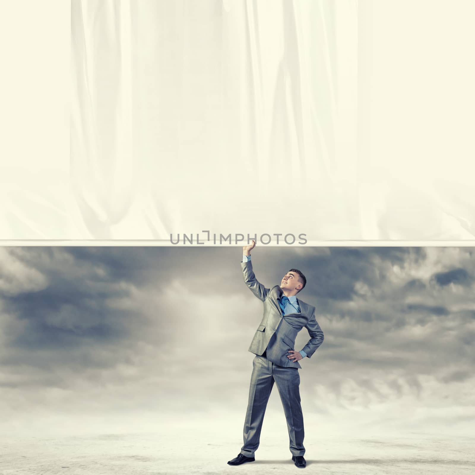 Image of young businessman pulling blank banner from above