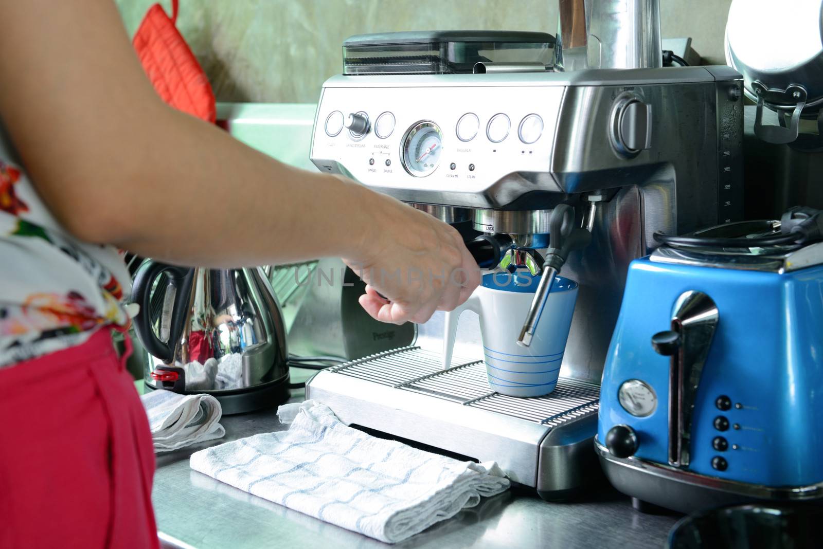 woman make a cup of coffee by coffee machine at home