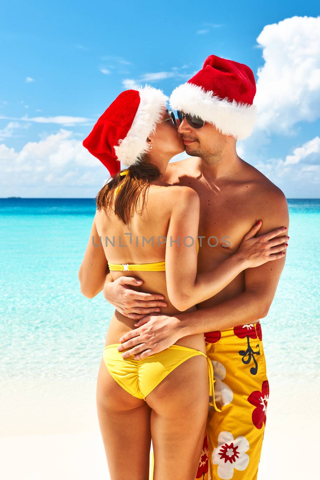 Couple in santa's hat on a beach at Maldives by haveseen