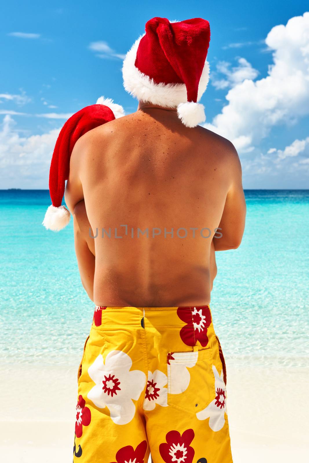 Couple in santa's hat on a tropical beach at Maldives