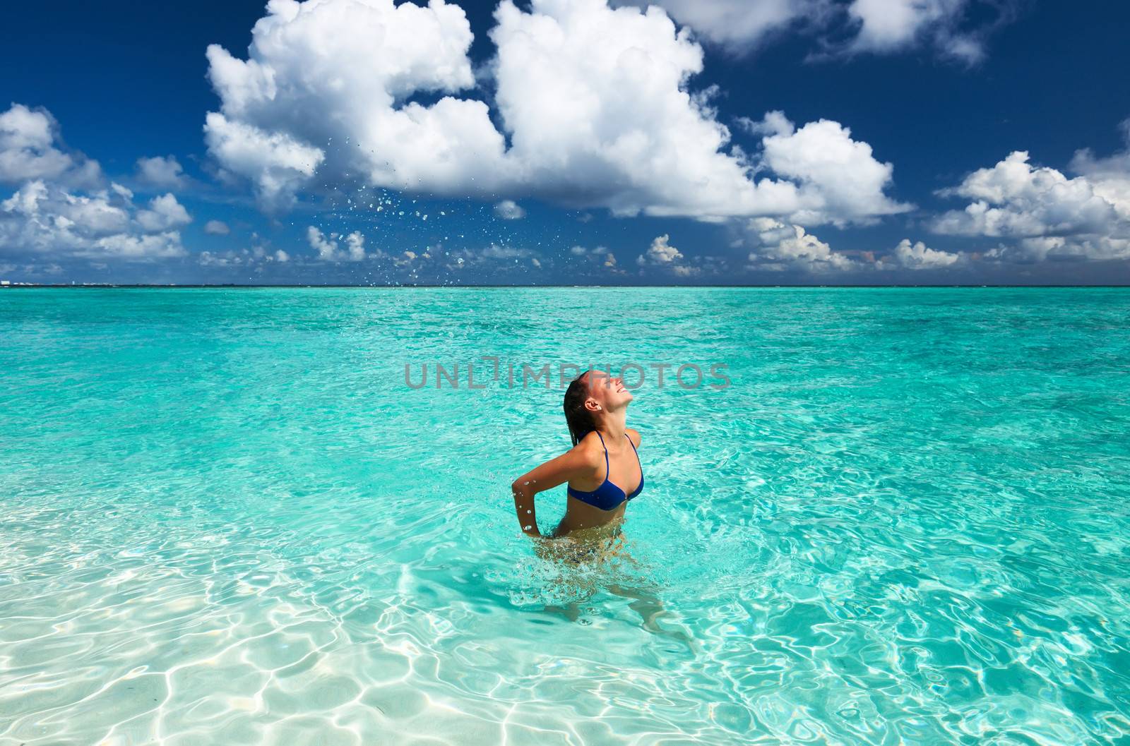 Woman splashing water with her hair in the ocean