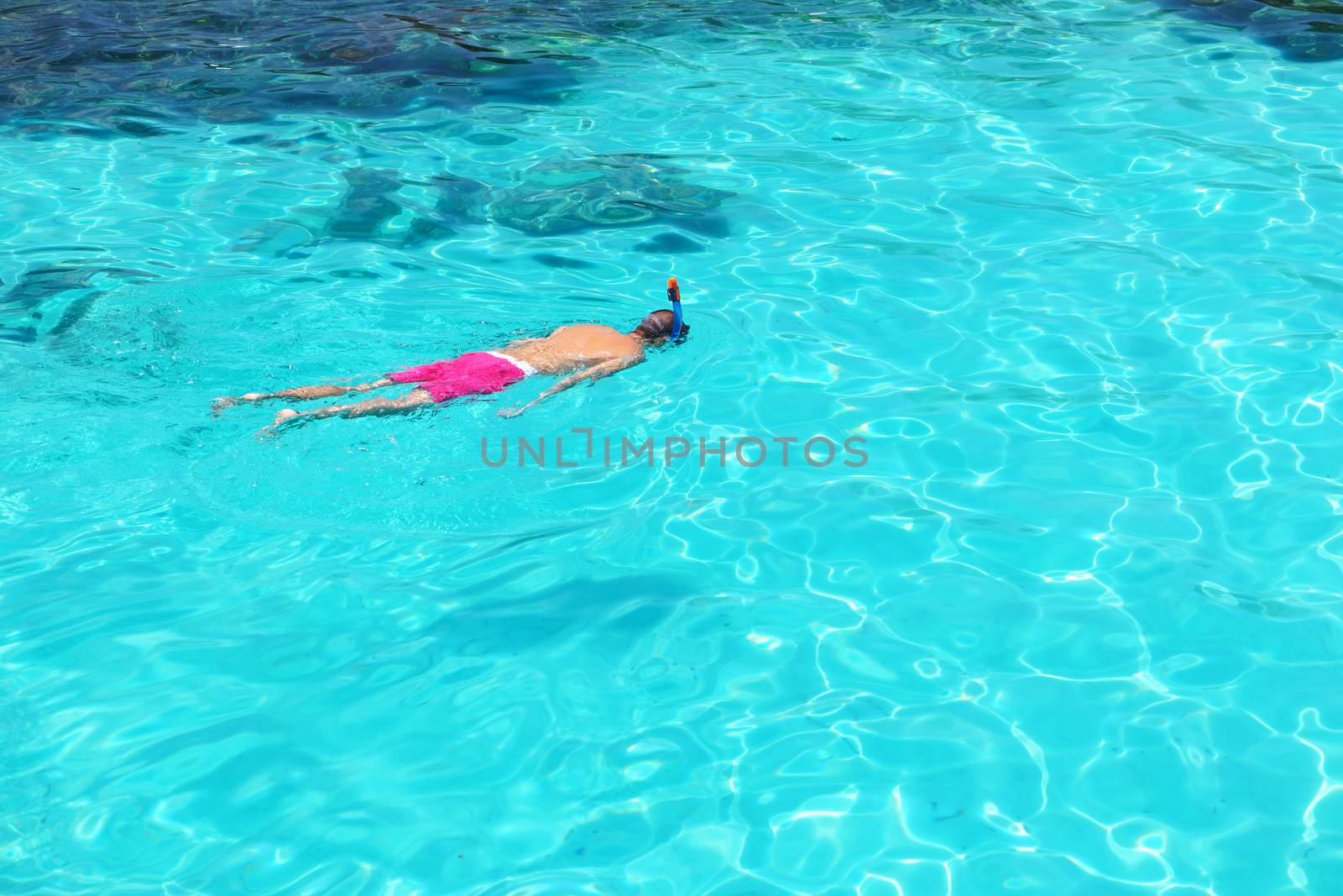 Man snorkeling in crystal clear turquoise water at tropical beach