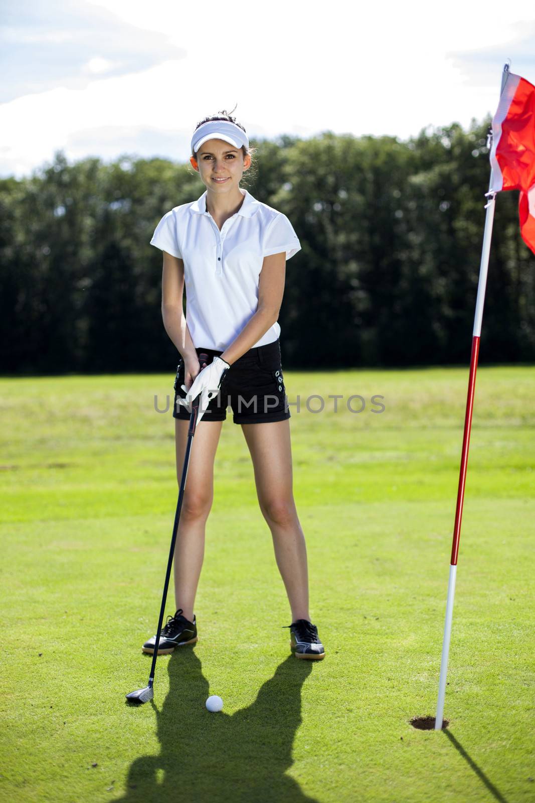 Pretty girl playing golf on grass by fikmik