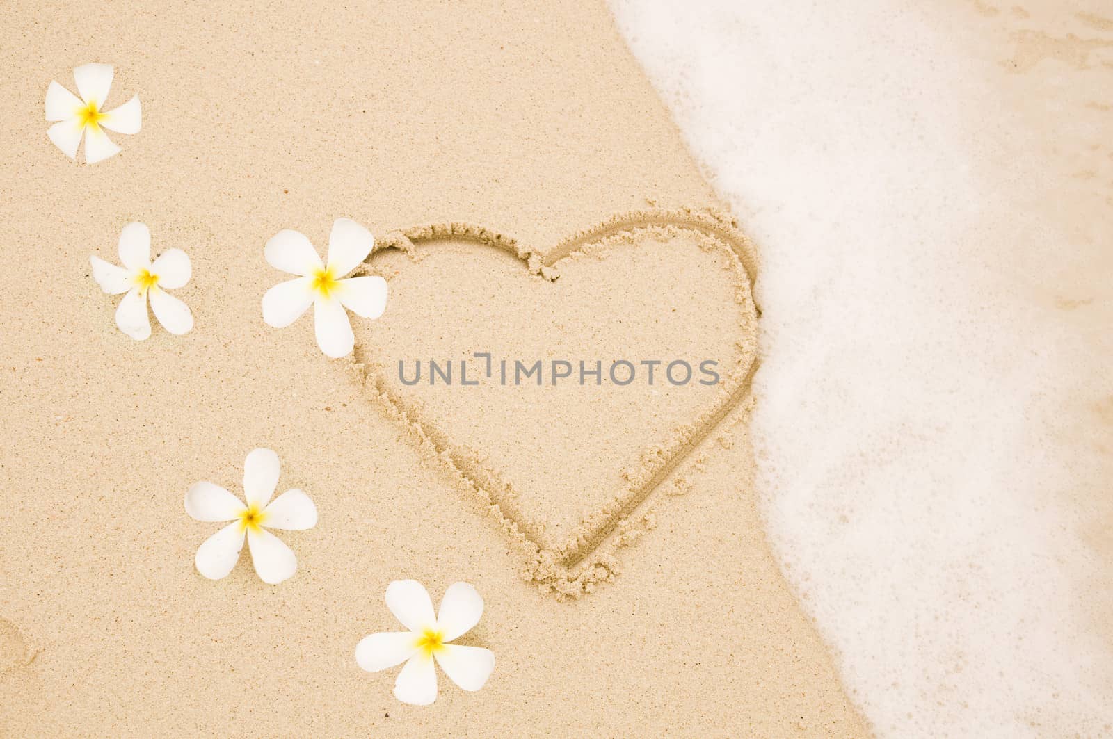 Handwritten heart on sand with wave approachin on Thailand