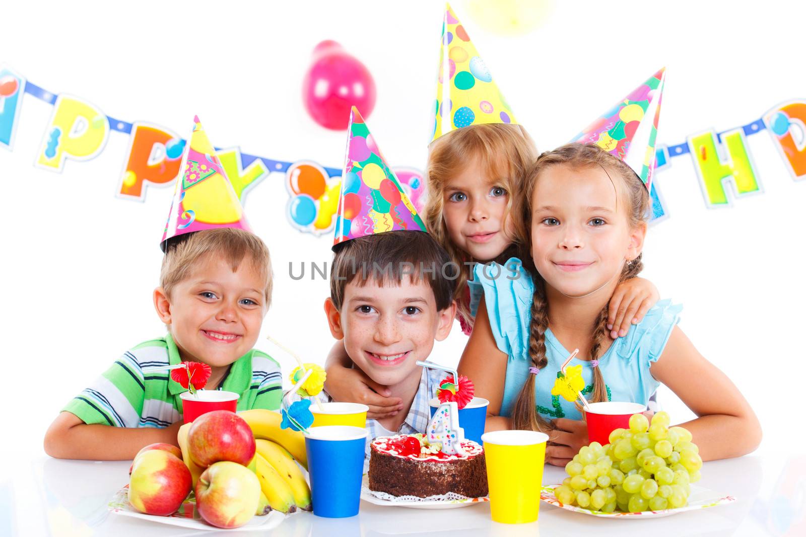 Group of adorable kids having fun at birthday party with birthday cake