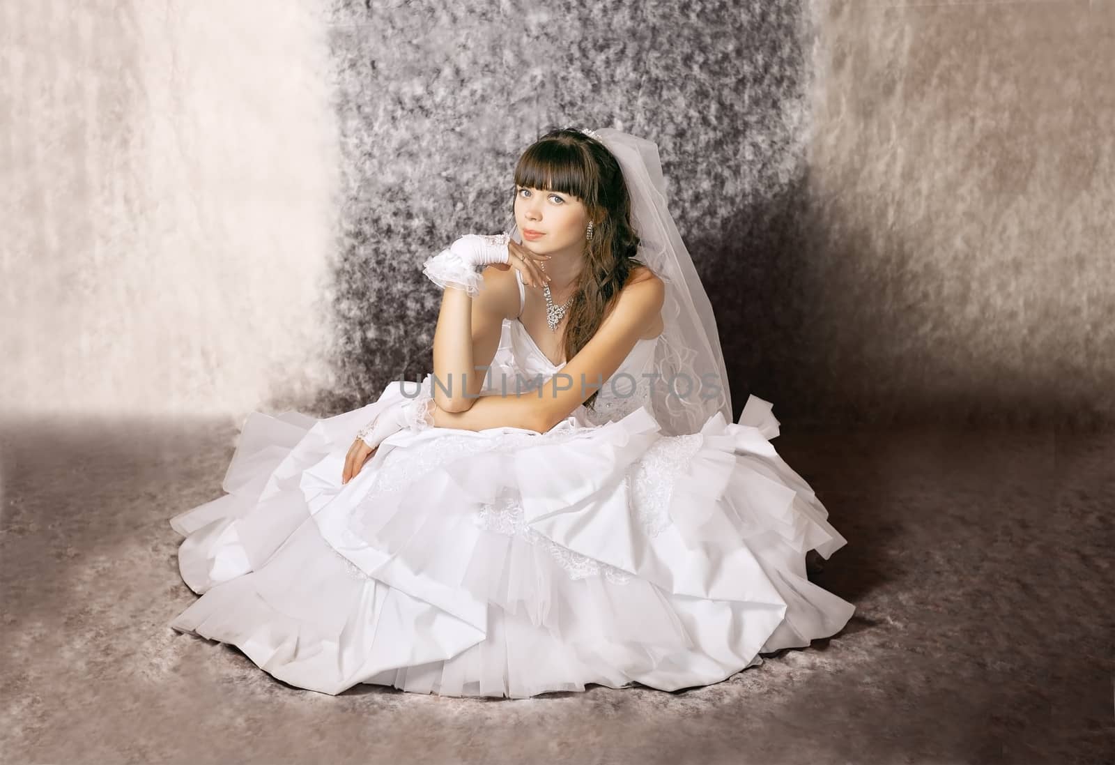 The bride with a thoughtful expression on his face in a wedding dress in a sitting position