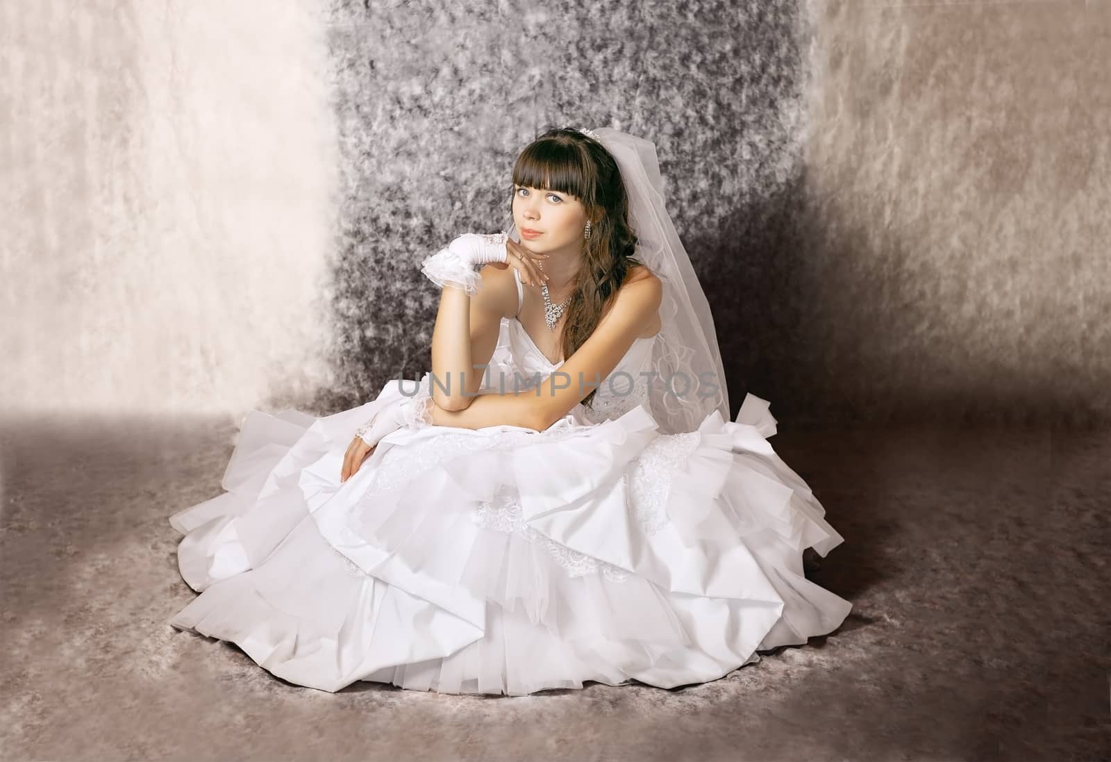 The bride with a thoughtful expression on his face in a wedding dress in a sitting position