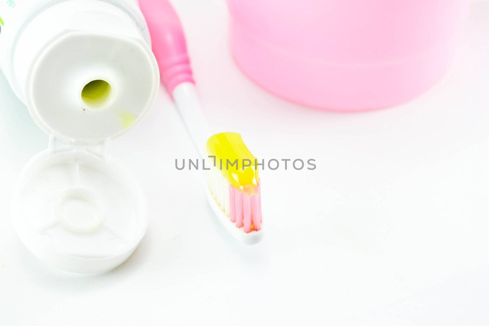Toothbrush and toothpaste on white background by Thanamat