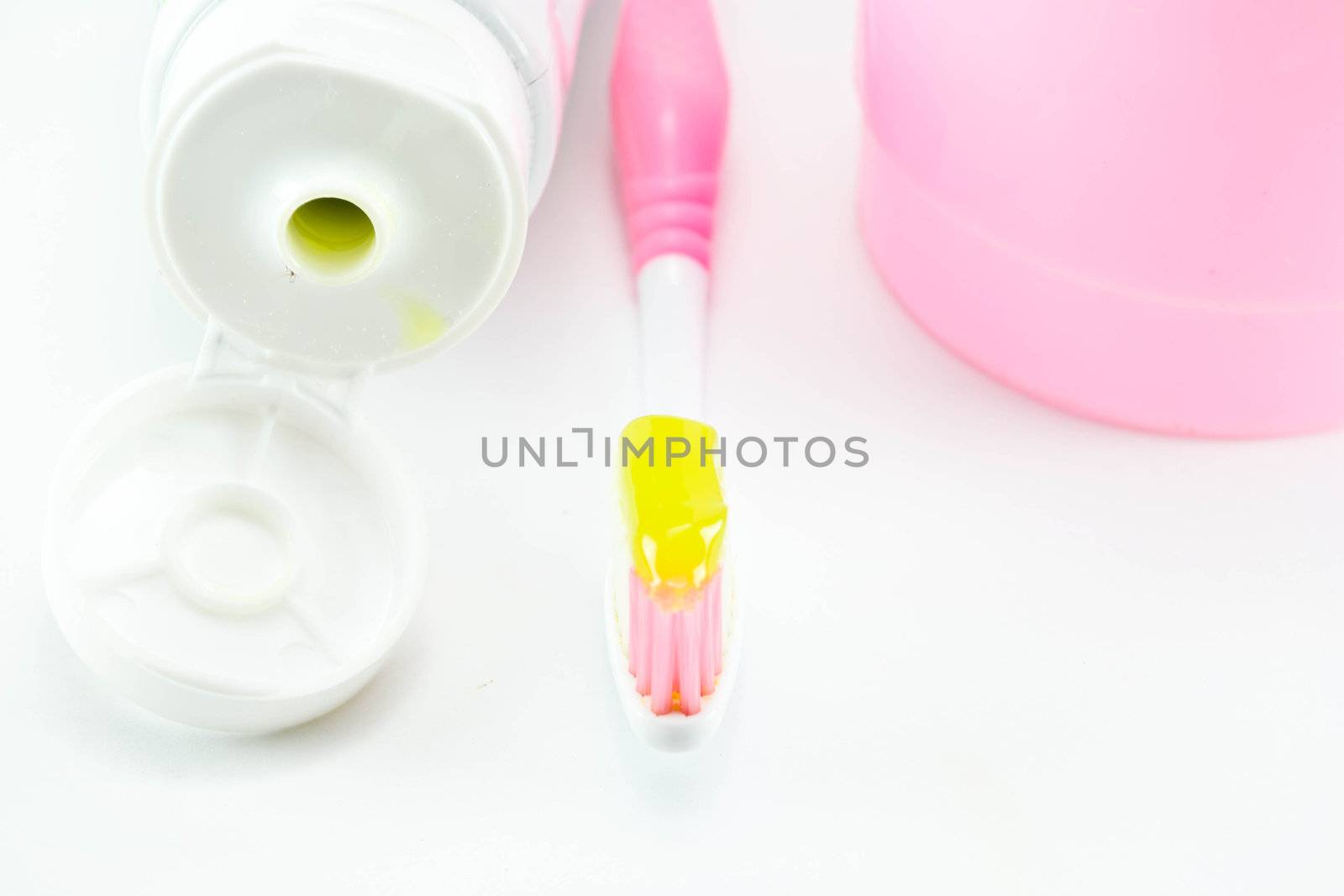 Toothbrush and toothpaste on white background by Thanamat