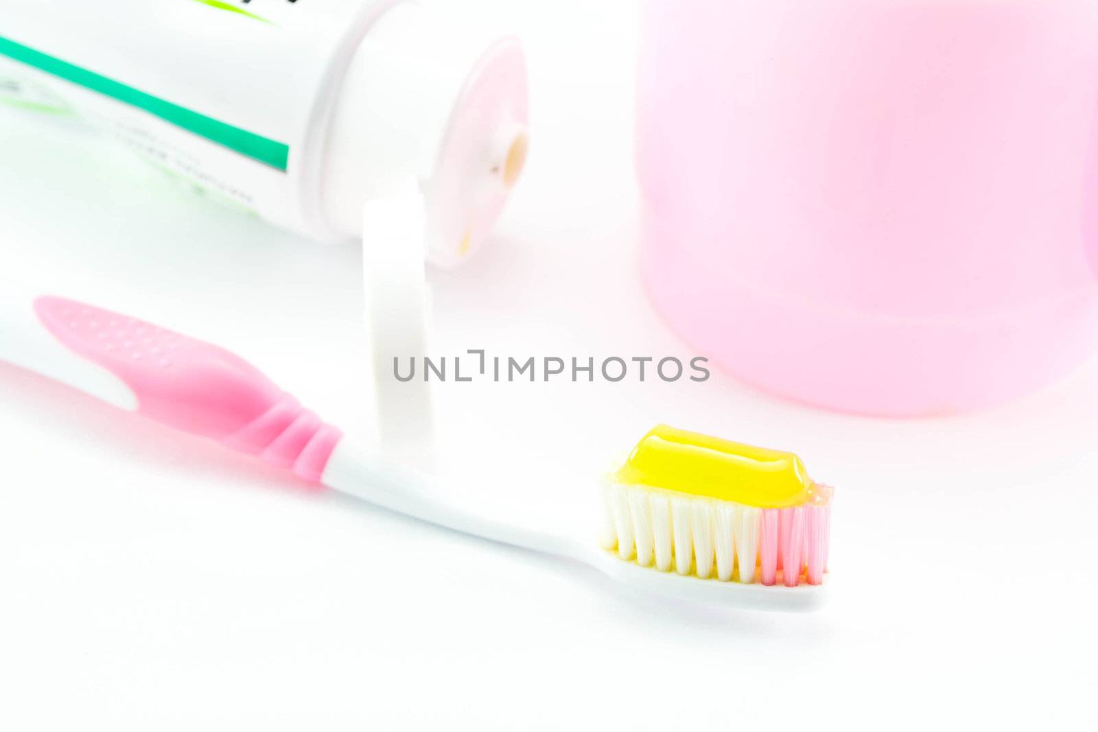 Toothbrush and toothpaste on white background by Thanamat