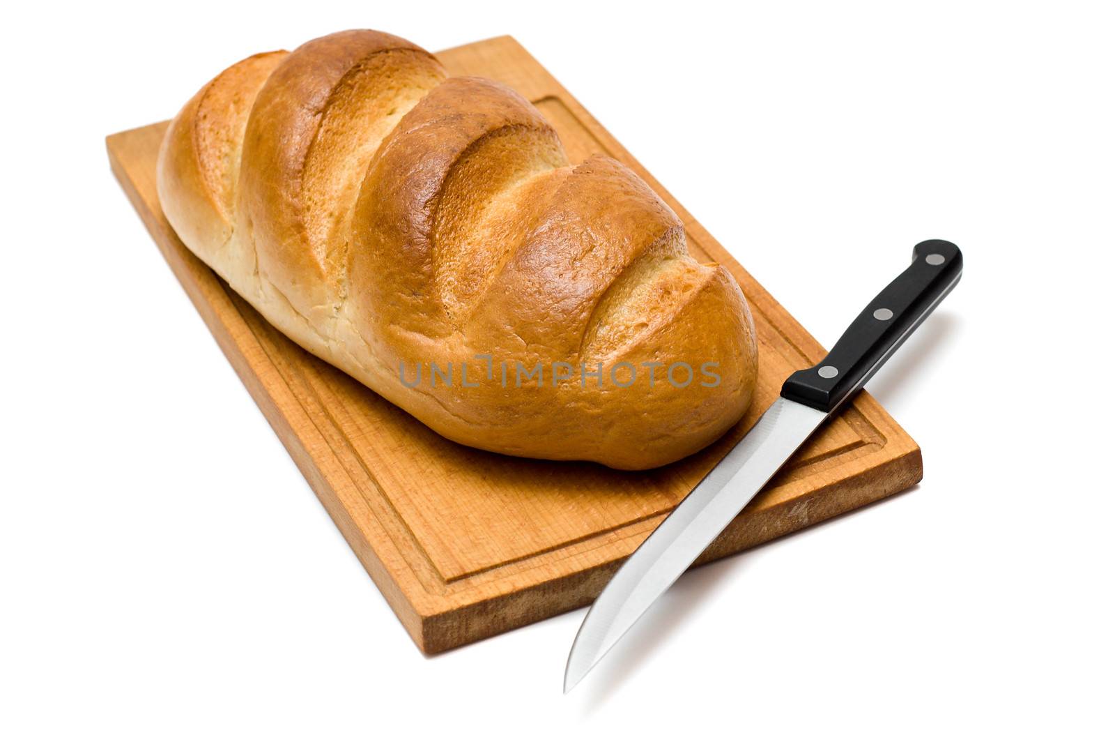 fresh natural bread with knife on breadboard