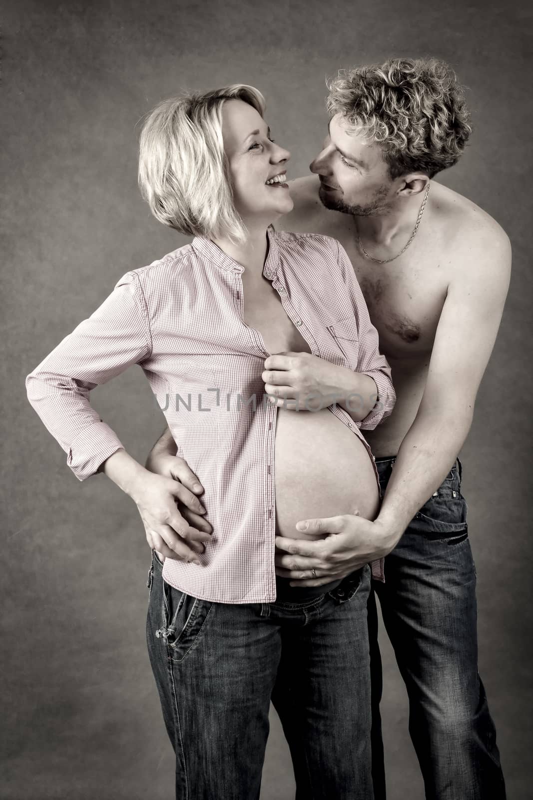Loving happy couple, pregnant woman with her husband, toned, looking at each other