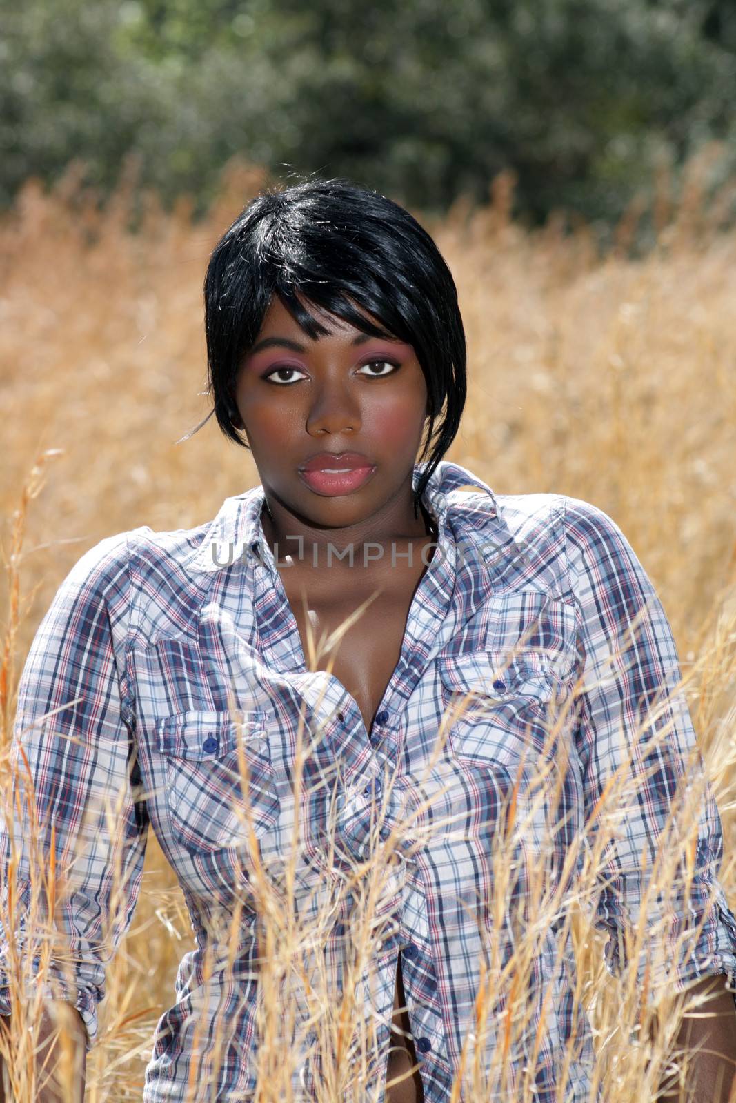 Close-up of a lovely young woman standing in tall grass.