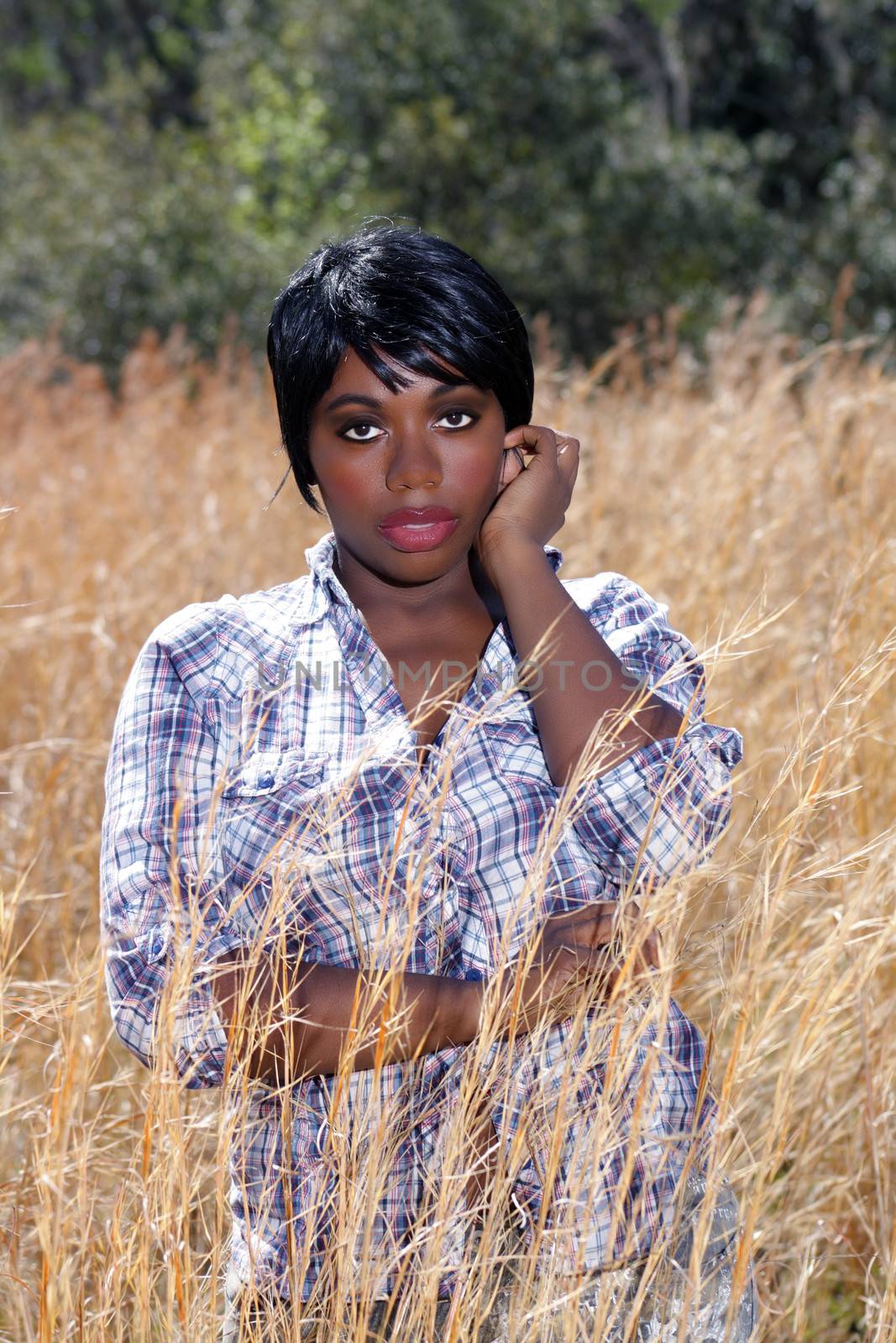 Close-up of a lovely young woman standing in tall grass.