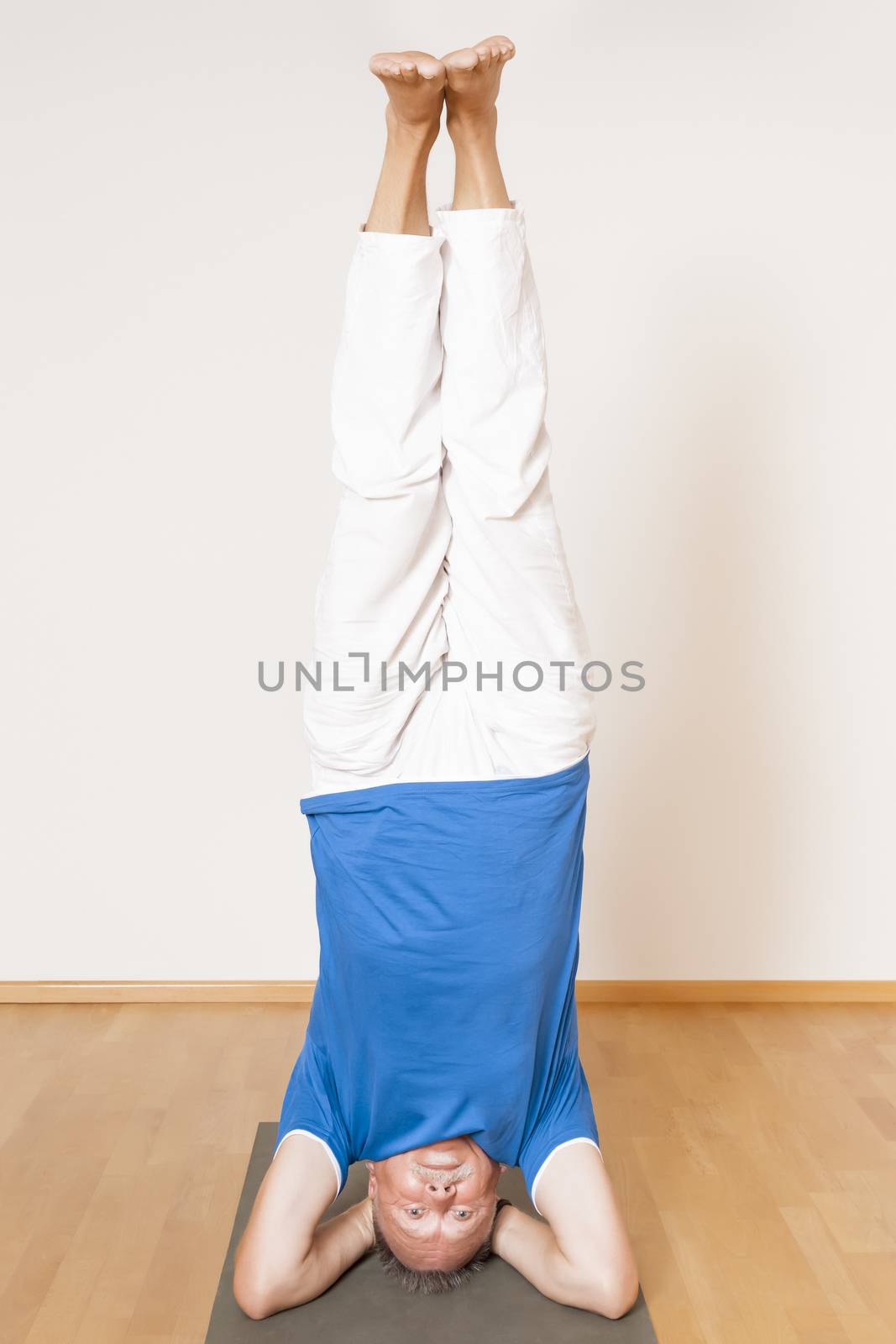 An image of a man doing yoga exercises - Salamba Shirshasana Head Stand