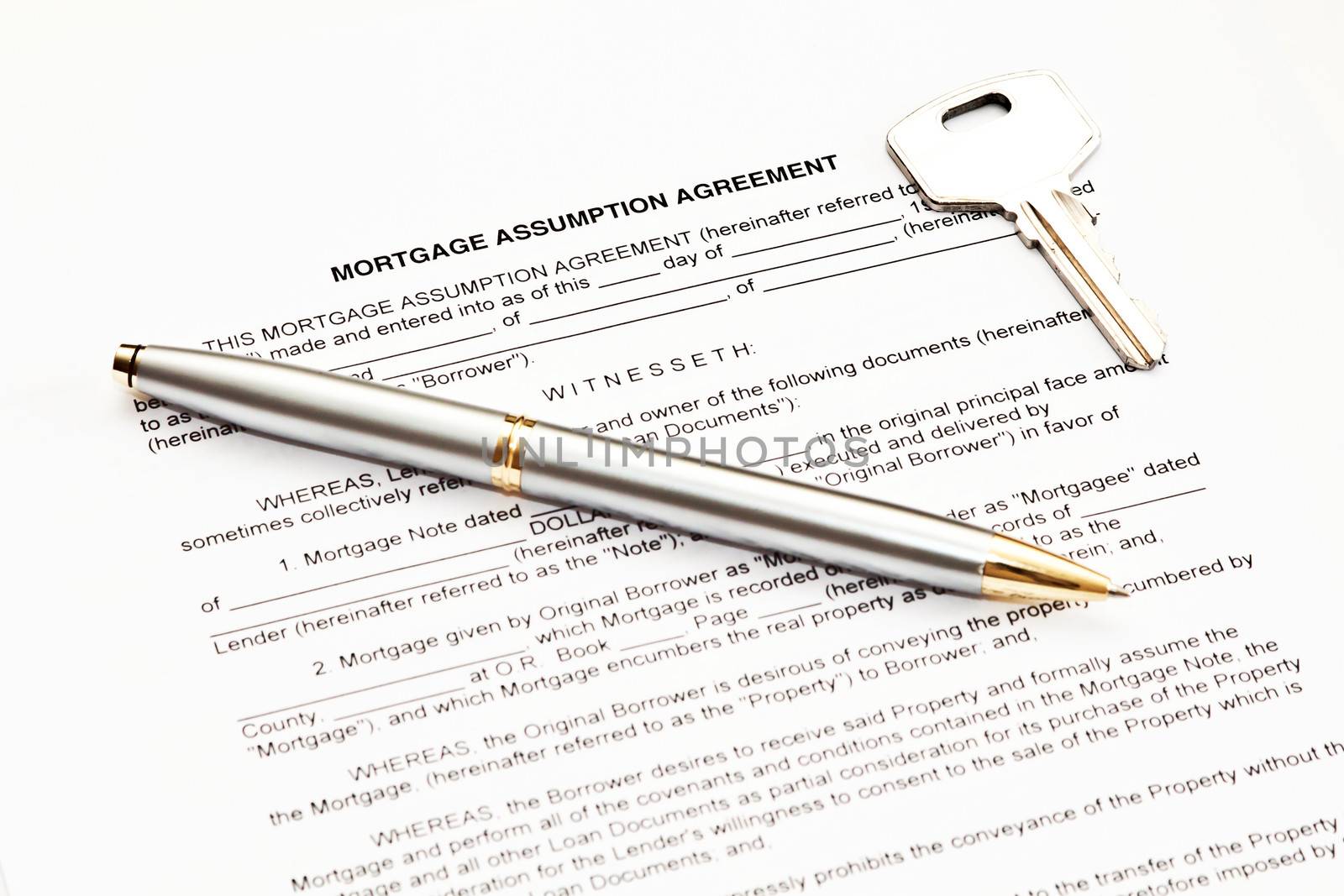 Mortgage assumption agreement with a pen for signature and a key
