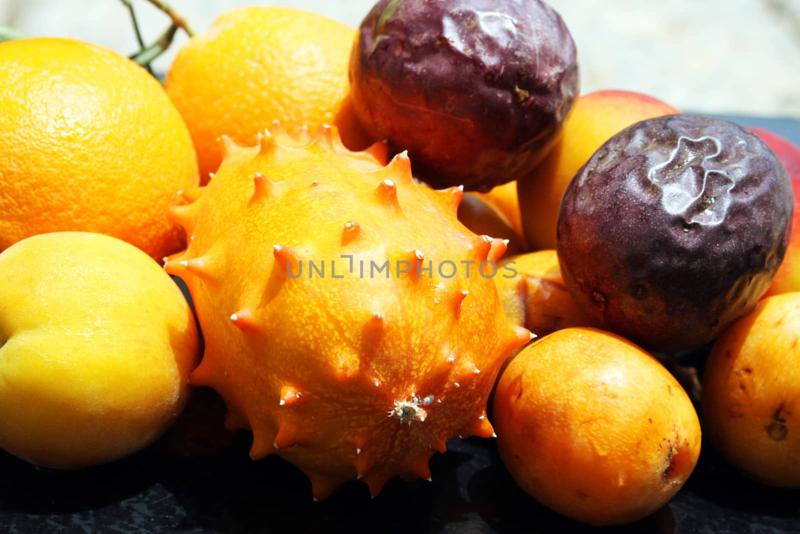 Exotic fruits: orange, kiwano, loquat, peach and passionfruit
