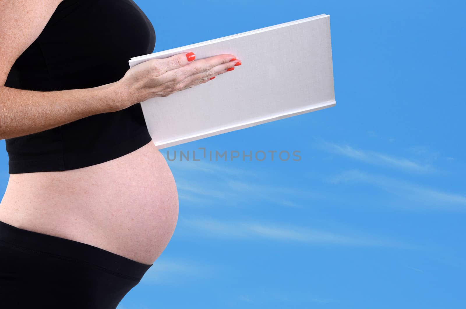 pregnancy - expectant mother reading to belly to her unborn child