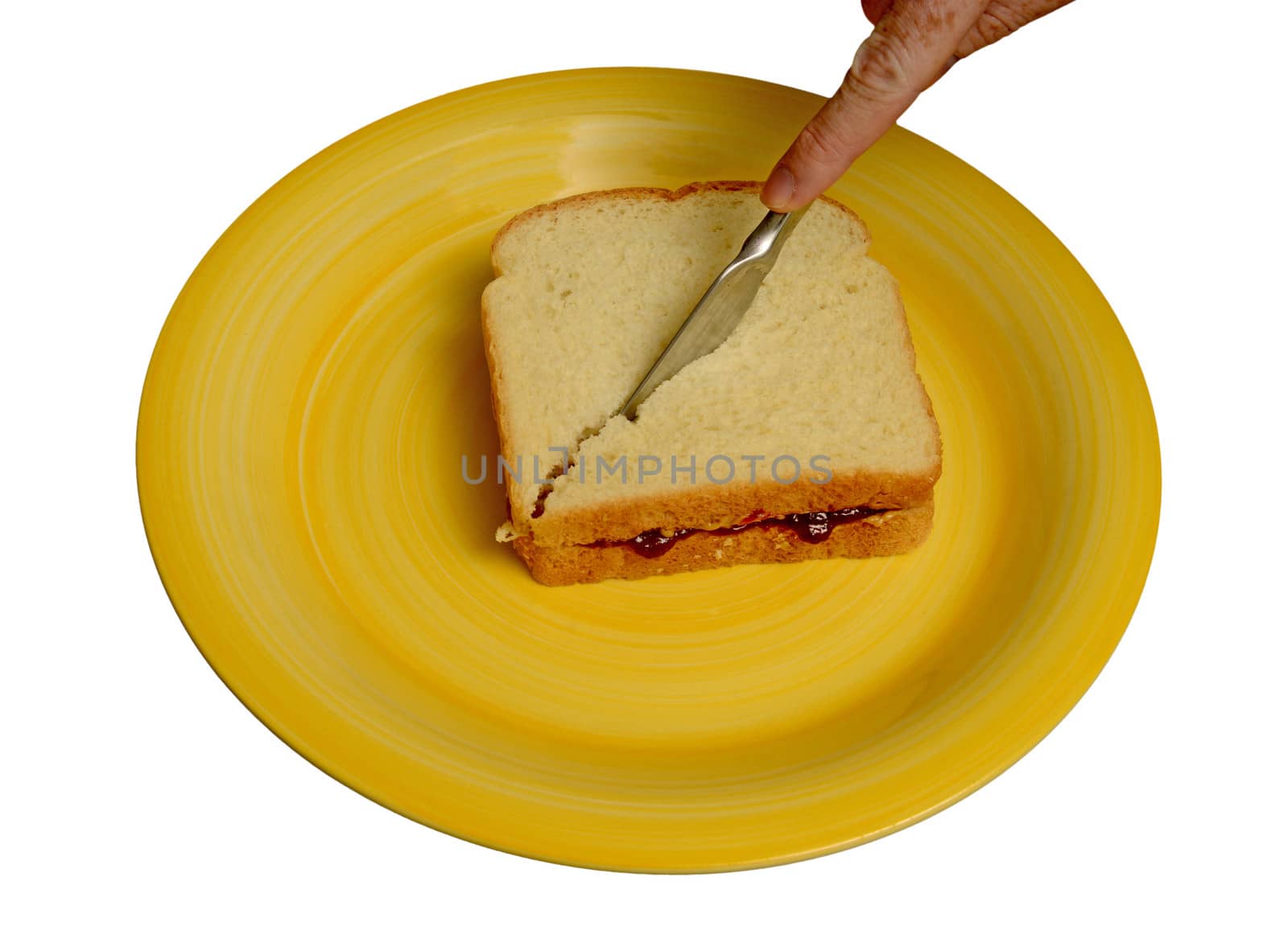 slicing peanut butter and jelly sandwich on a yellow plate by ftlaudgirl