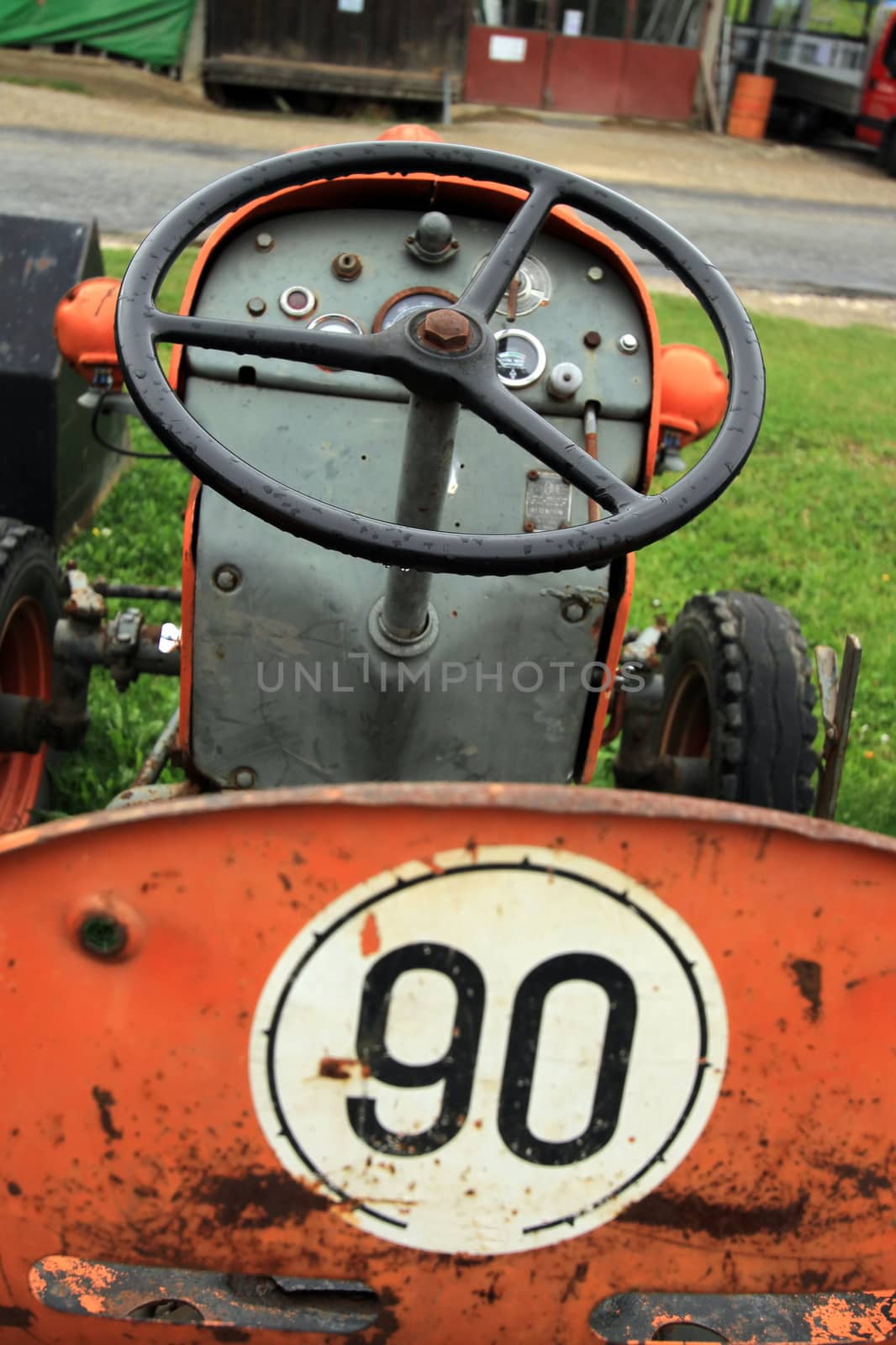 Close up of red antique tractor seat and wheel