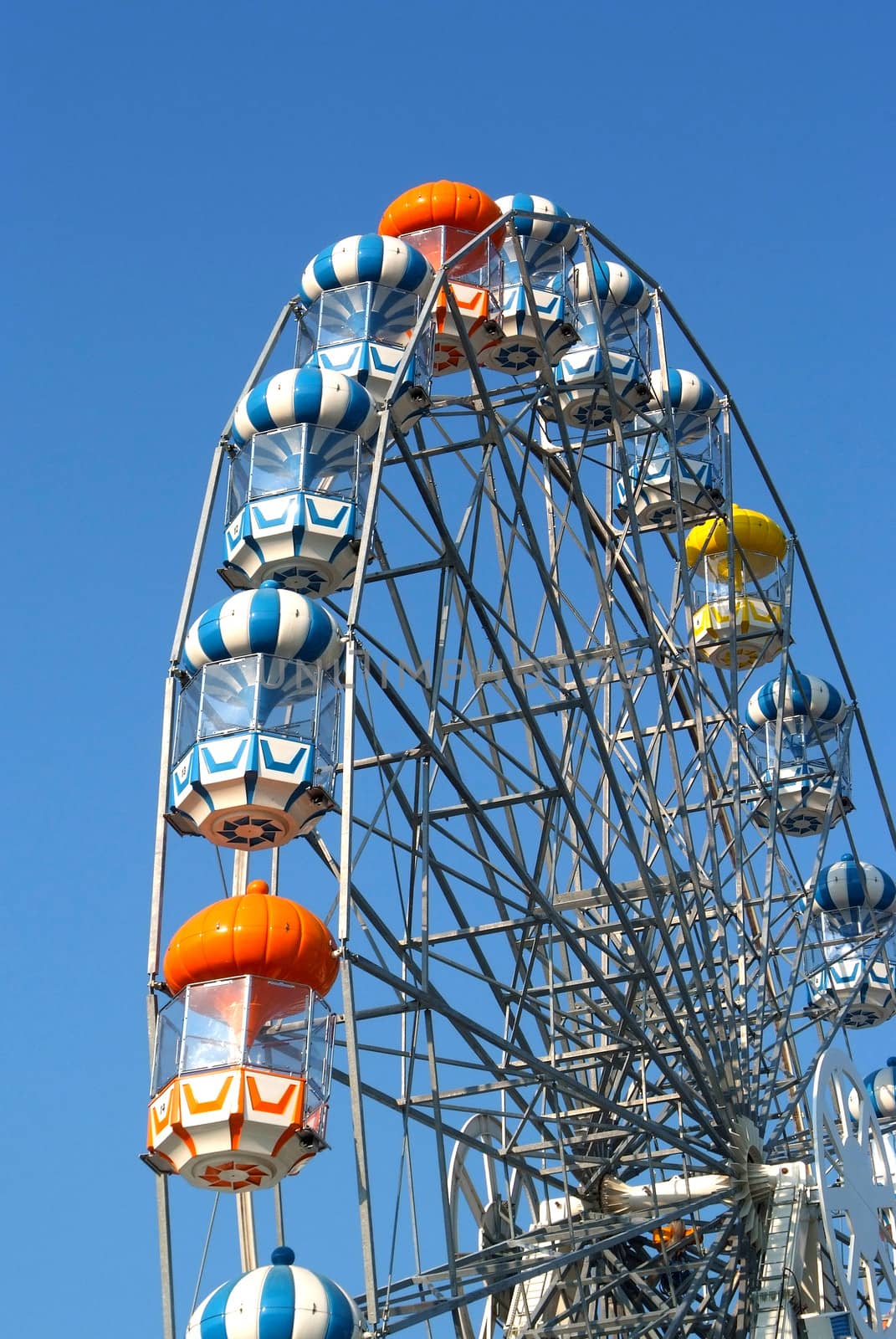 Colored Ferris wheel with blue sky by opasstudio