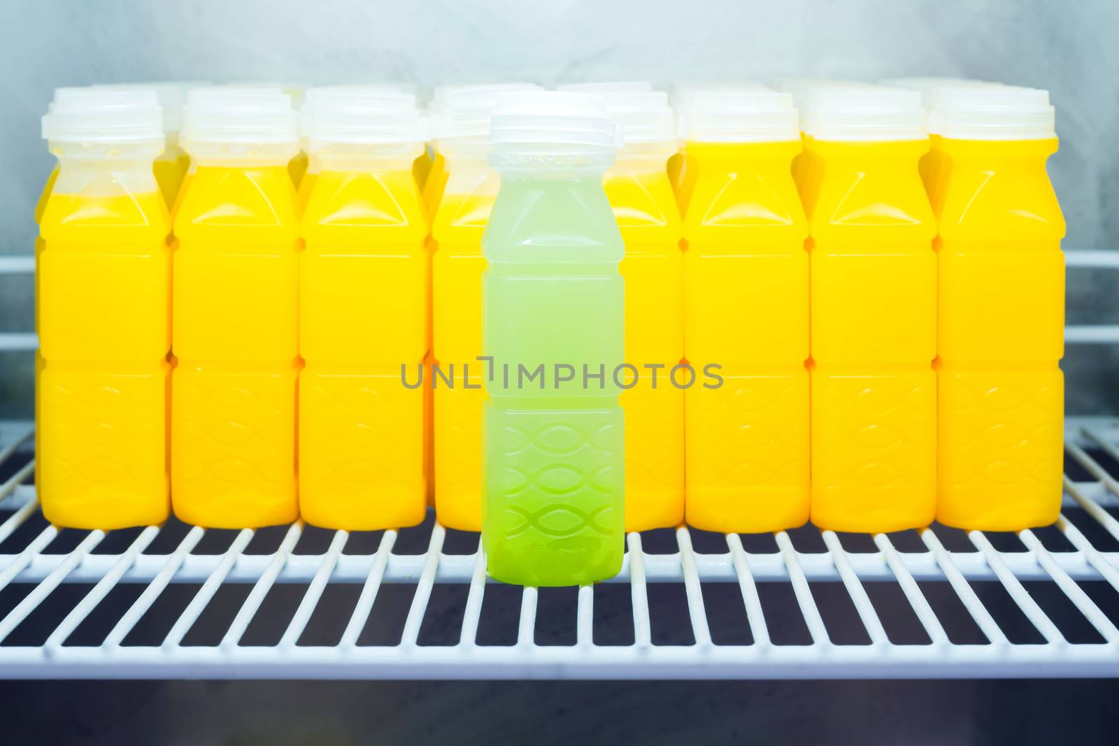 Guava juice against Orange juice bottles in refrigerator, leadership concept
