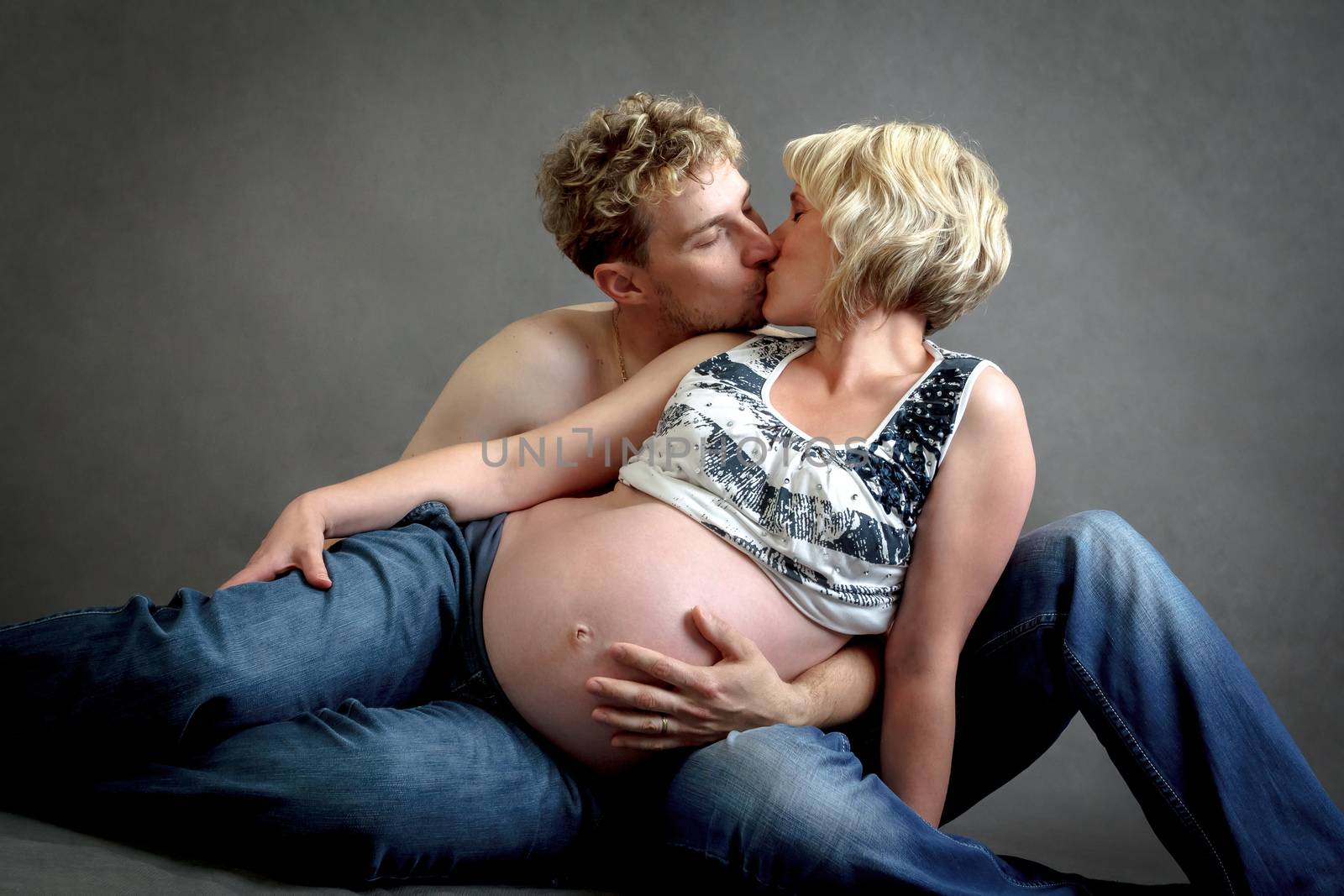 Loving happy couple, pregnant woman in love with her husband, romantic kissing scene