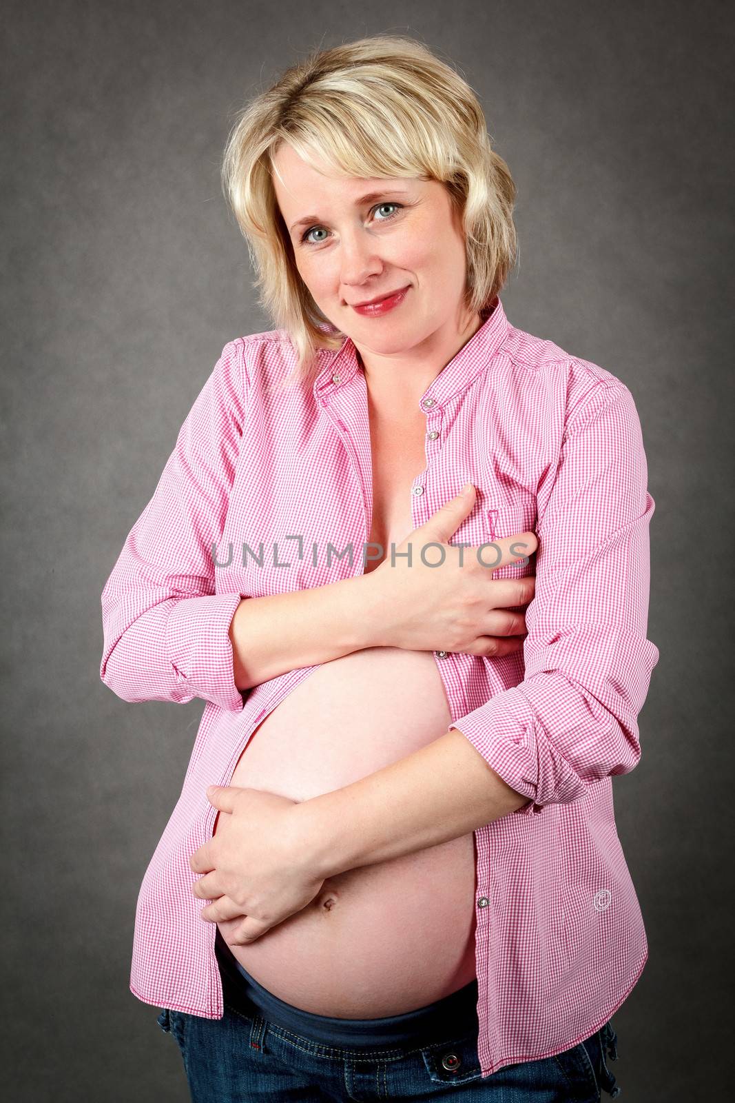 beautiful smiling pregnant woman tenderly holding her tummy