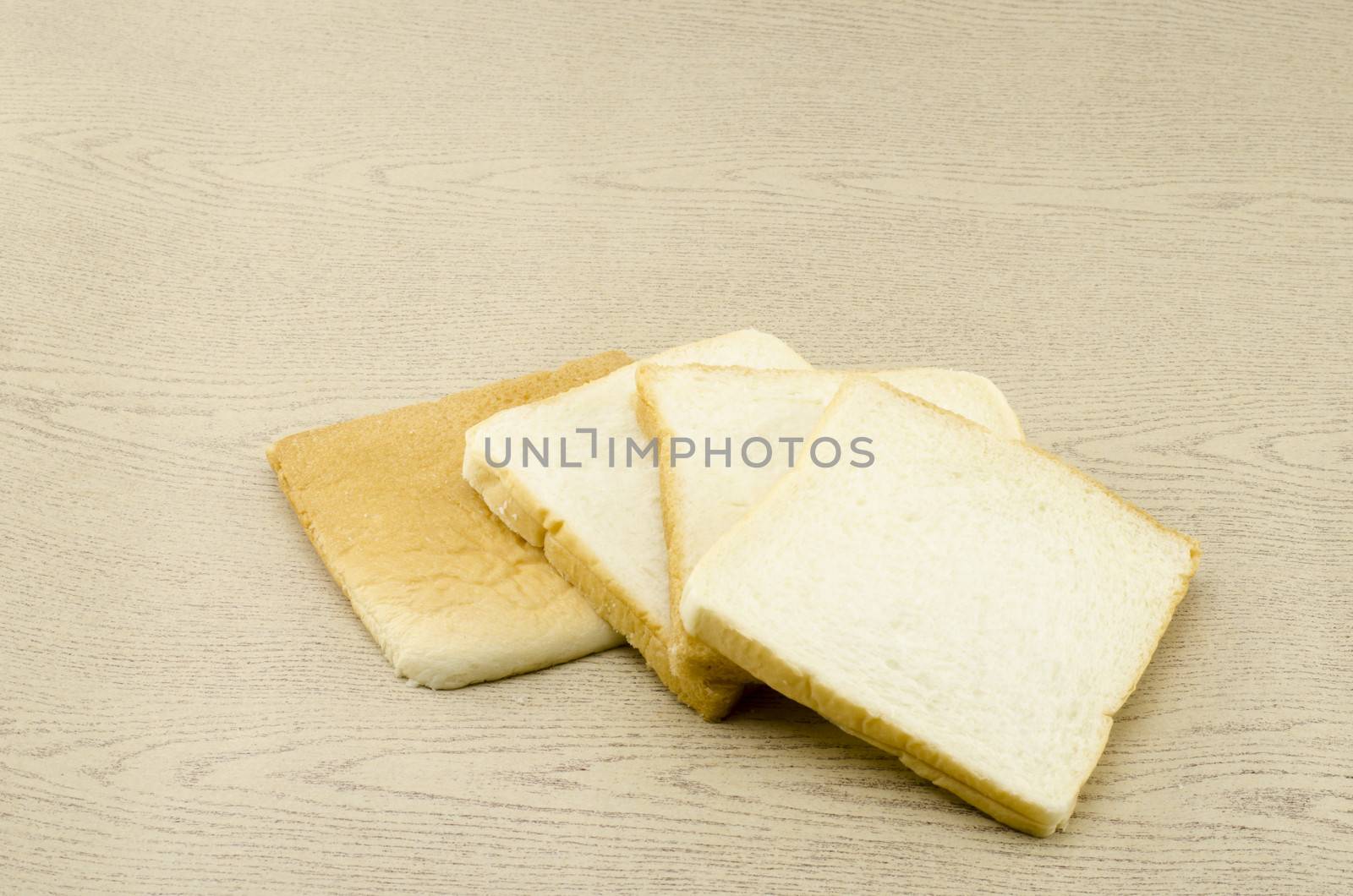 sliced bread on brown wood  by ammza12