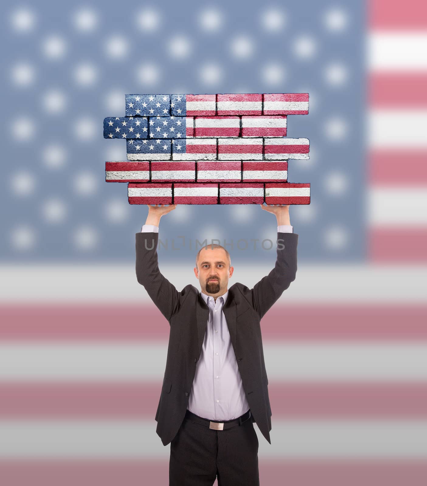 Businessman holding a large piece of a brick wall, flag of United States, isolated on national flag